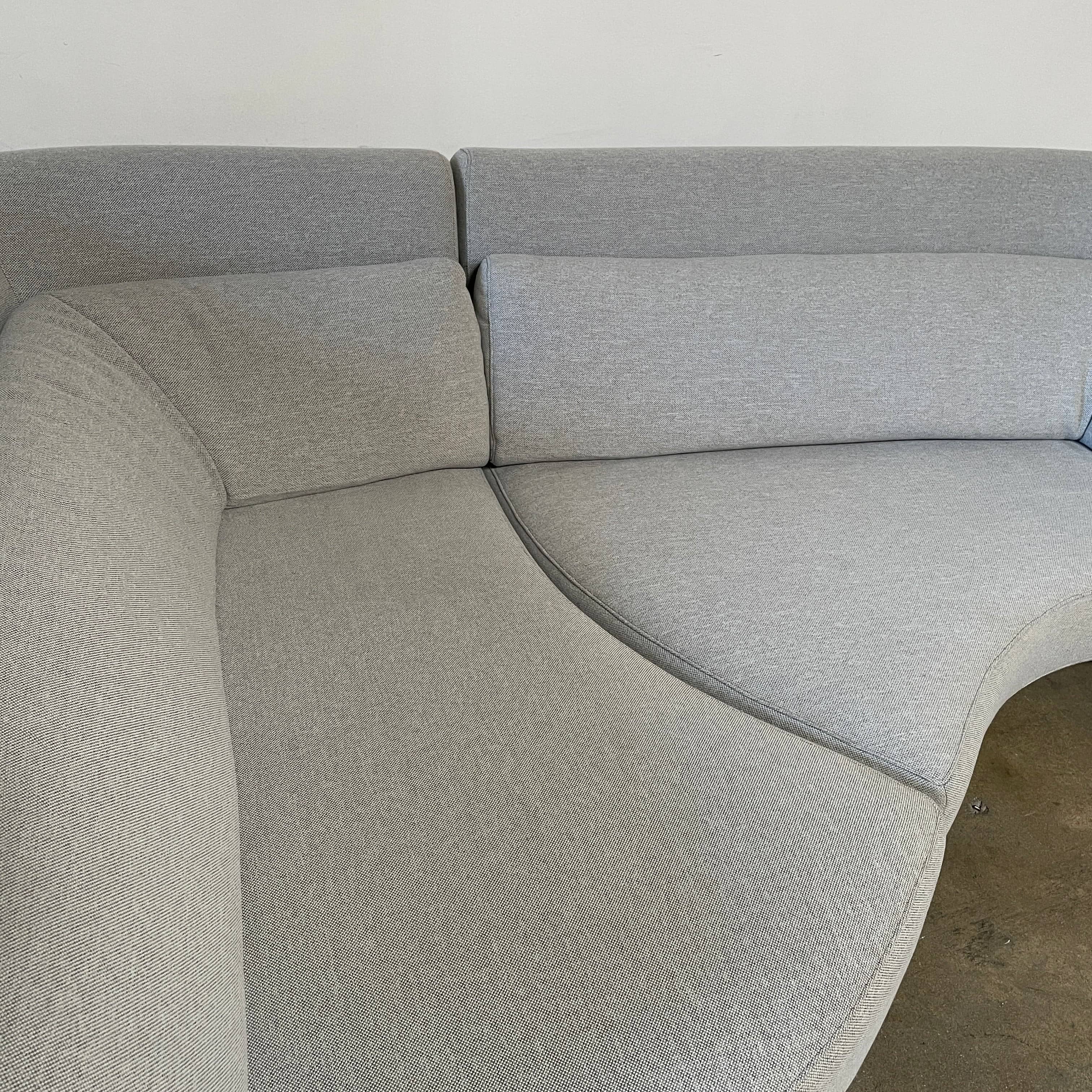 Modern curved Ligne Roset Yang Sectional sofa in durable wool fabric, isolated on a white background.