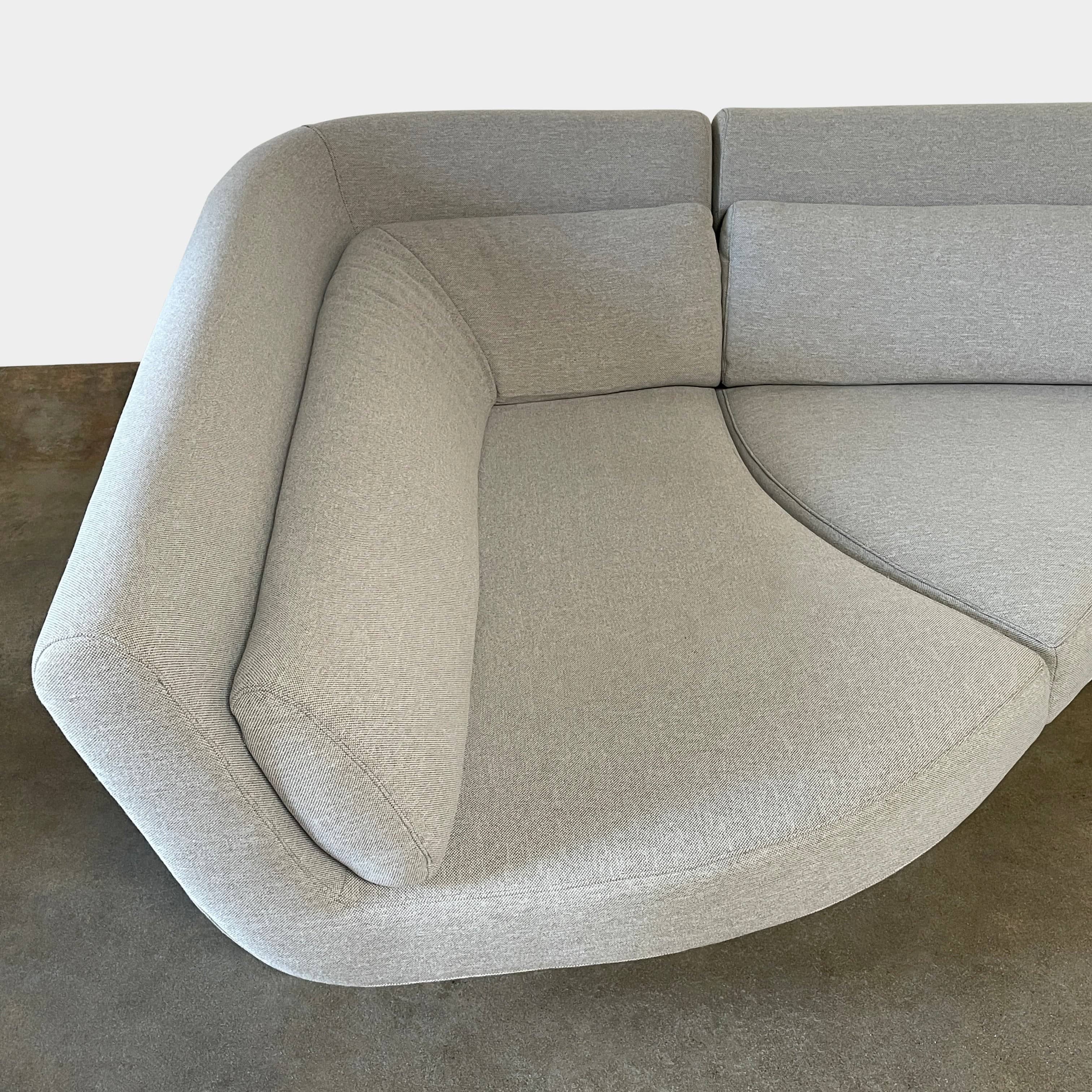 Modern curved Ligne Roset Yang Sectional sofa in durable wool fabric, isolated on a white background.