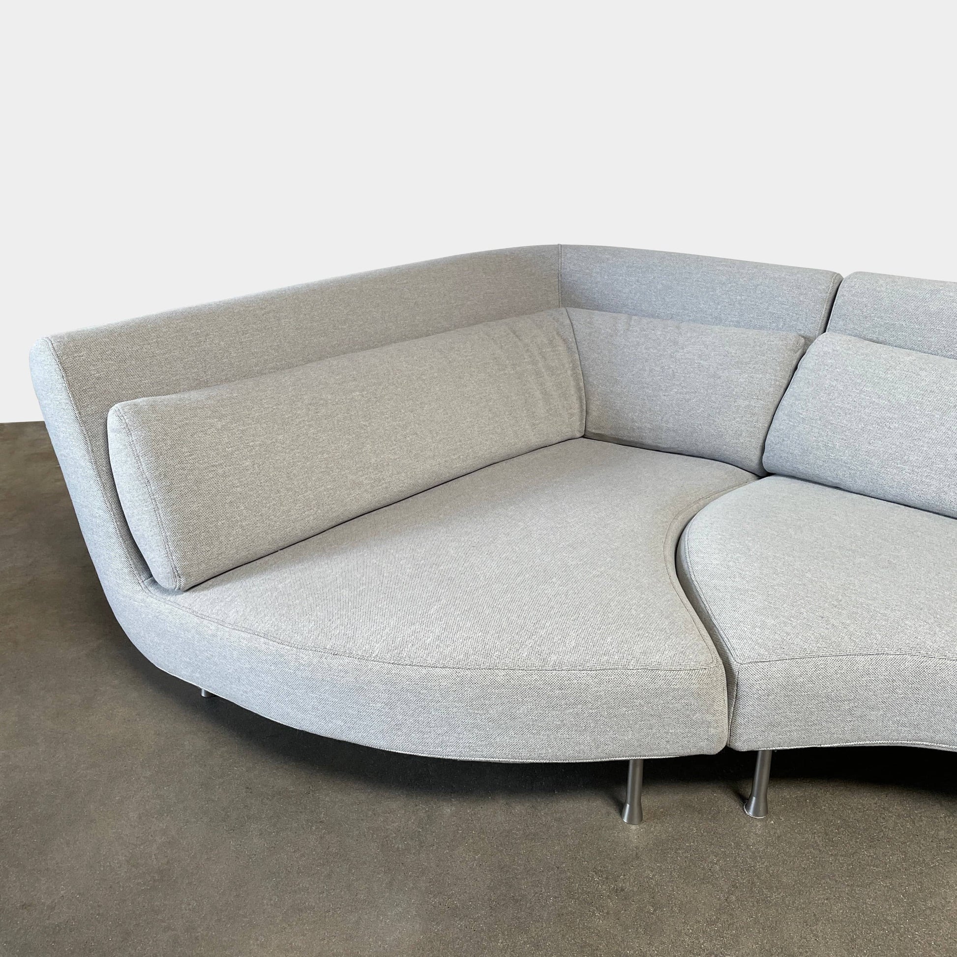 Modern curved Ligne Roset Yang Sectional sofa in durable wool fabric, isolated on a white background.