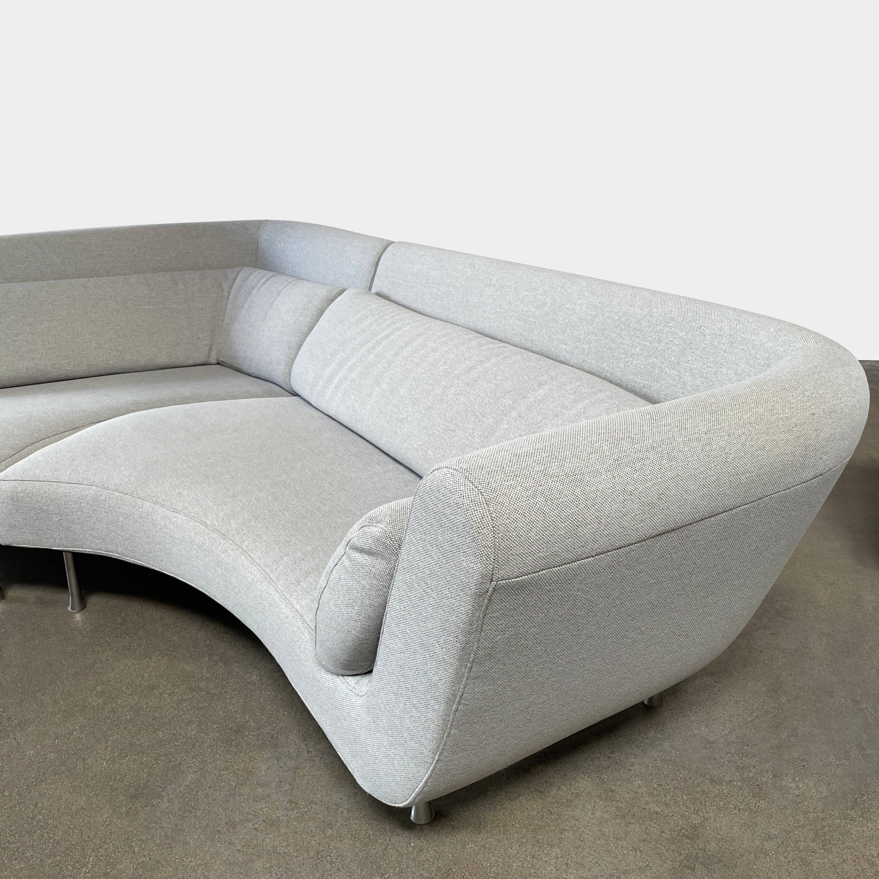 Modern curved Ligne Roset Yang Sectional sofa in durable wool fabric, isolated on a white background.
