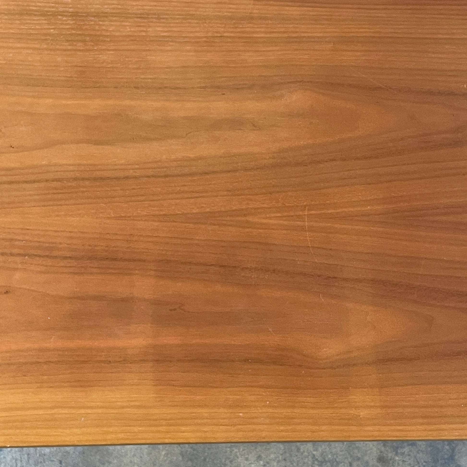 A Herman Miller Square Table with a black base and wooden top by Herman Miller.