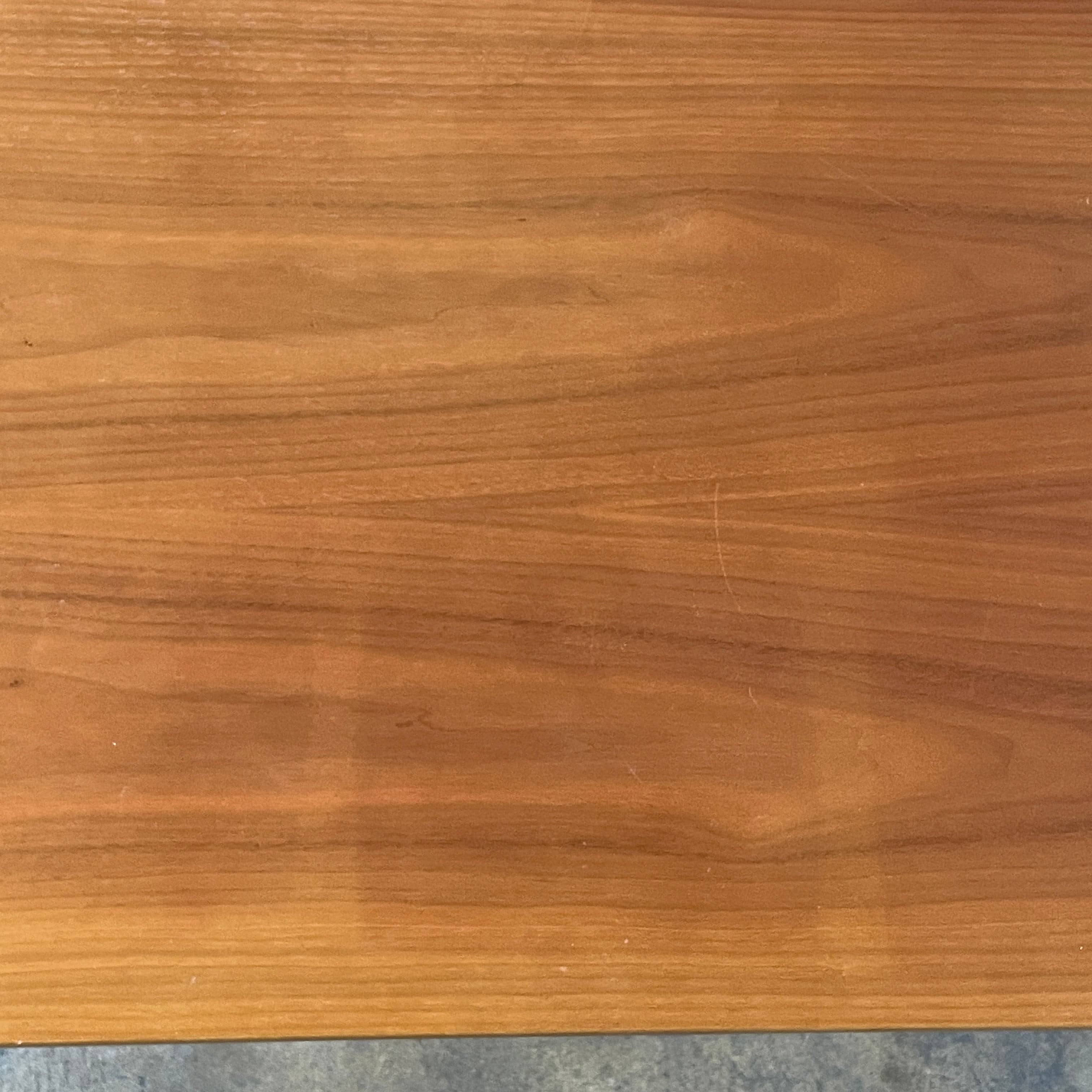 A Herman Miller Square Table with a black base and wooden top by Herman Miller.