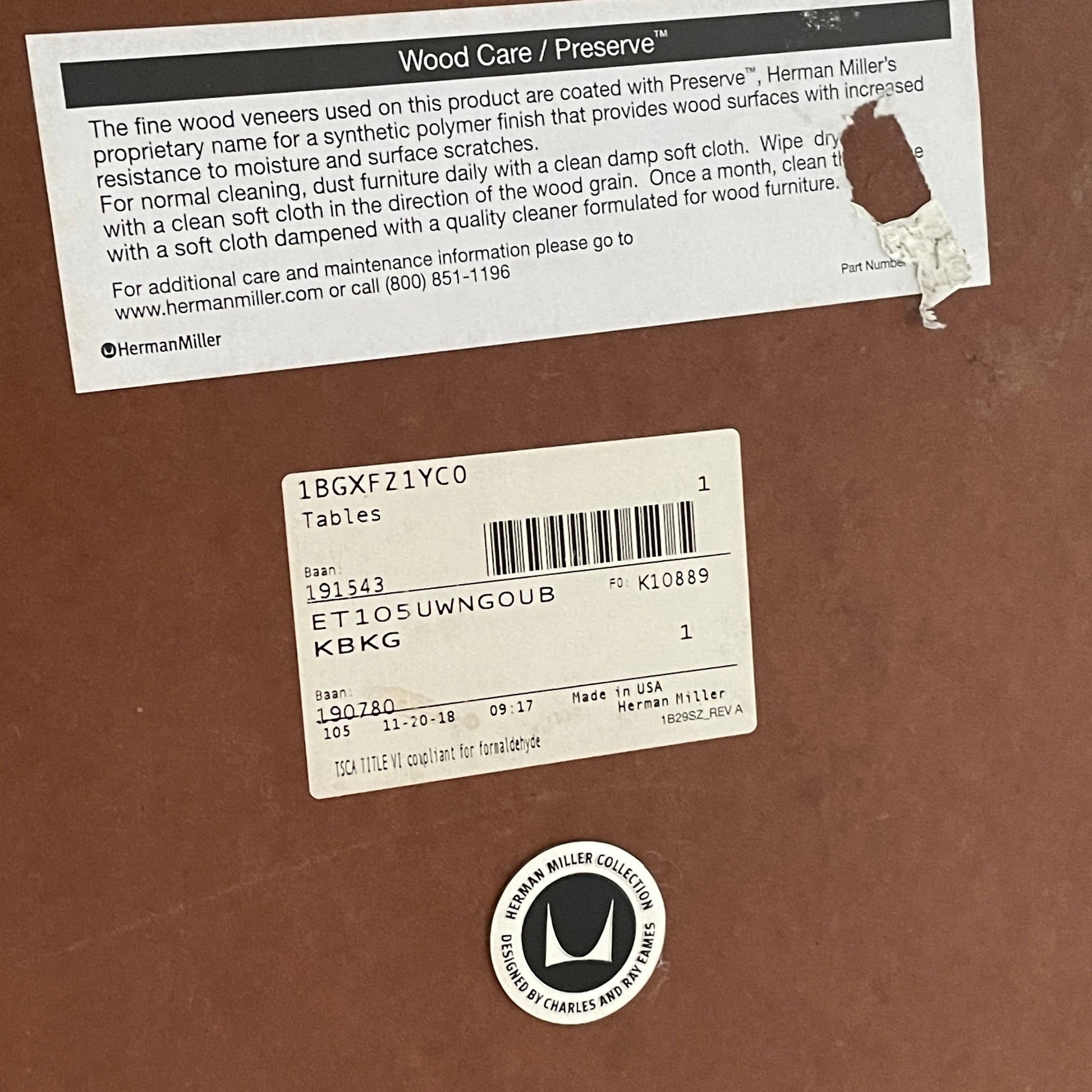 A Herman Miller Square Table with a black base and wooden top by Herman Miller.