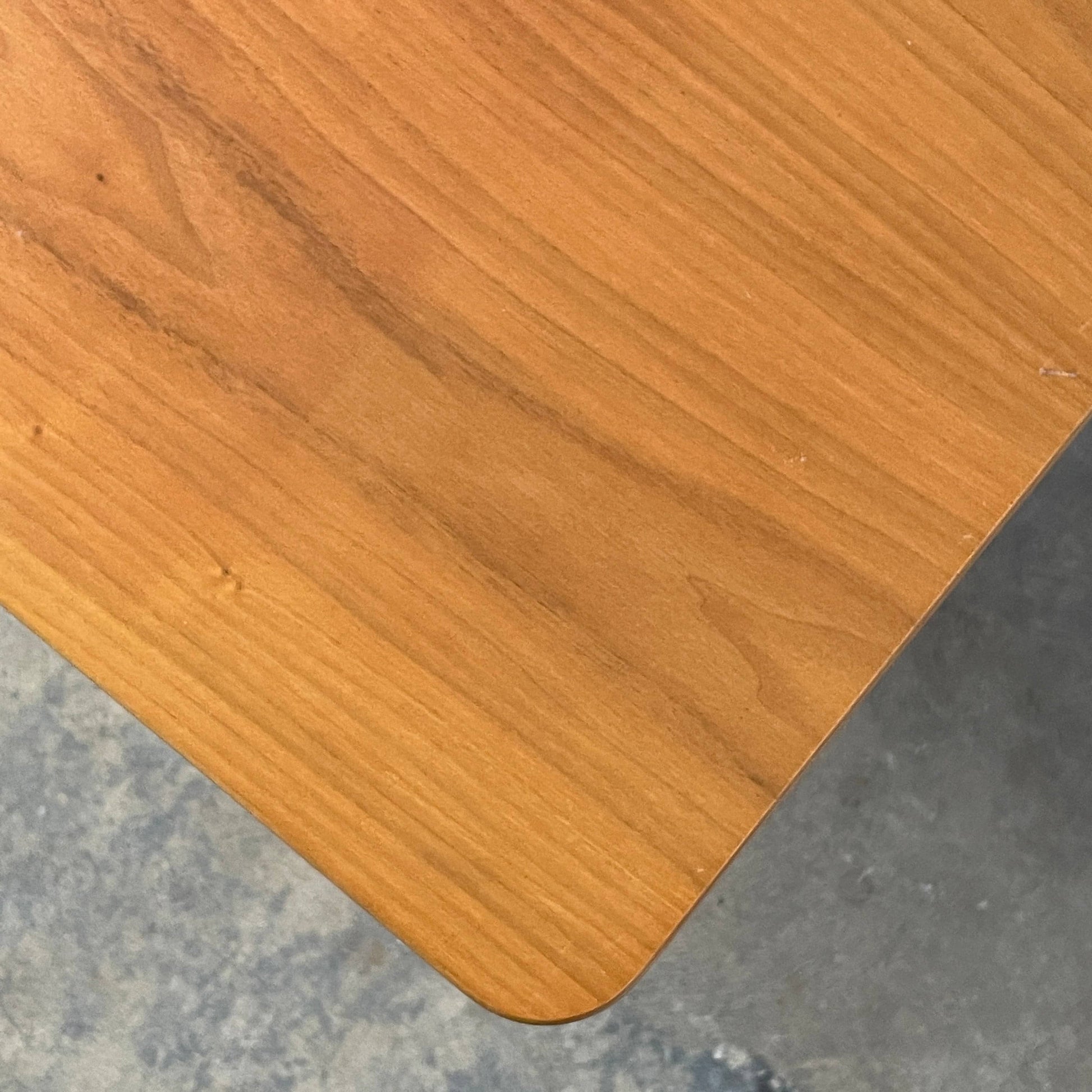 A Herman Miller Square Table with a black base and wooden top by Herman Miller.