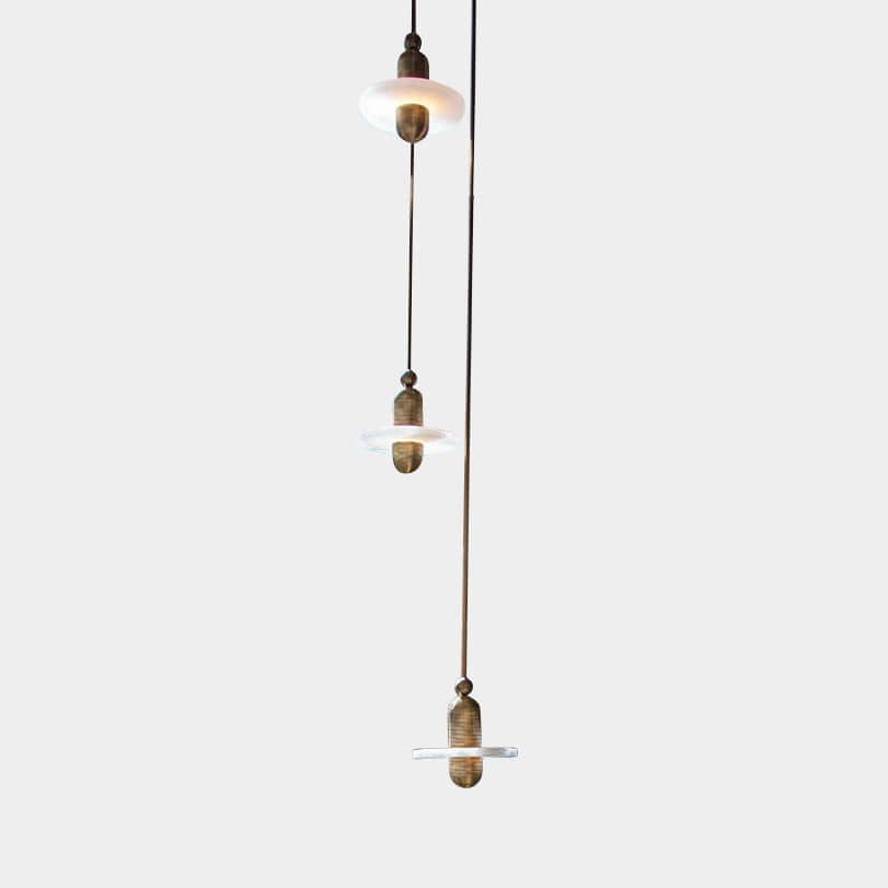 A contemporary Apparatus Studio Median Mono Five pendant ceiling light with three lights hanging from it.