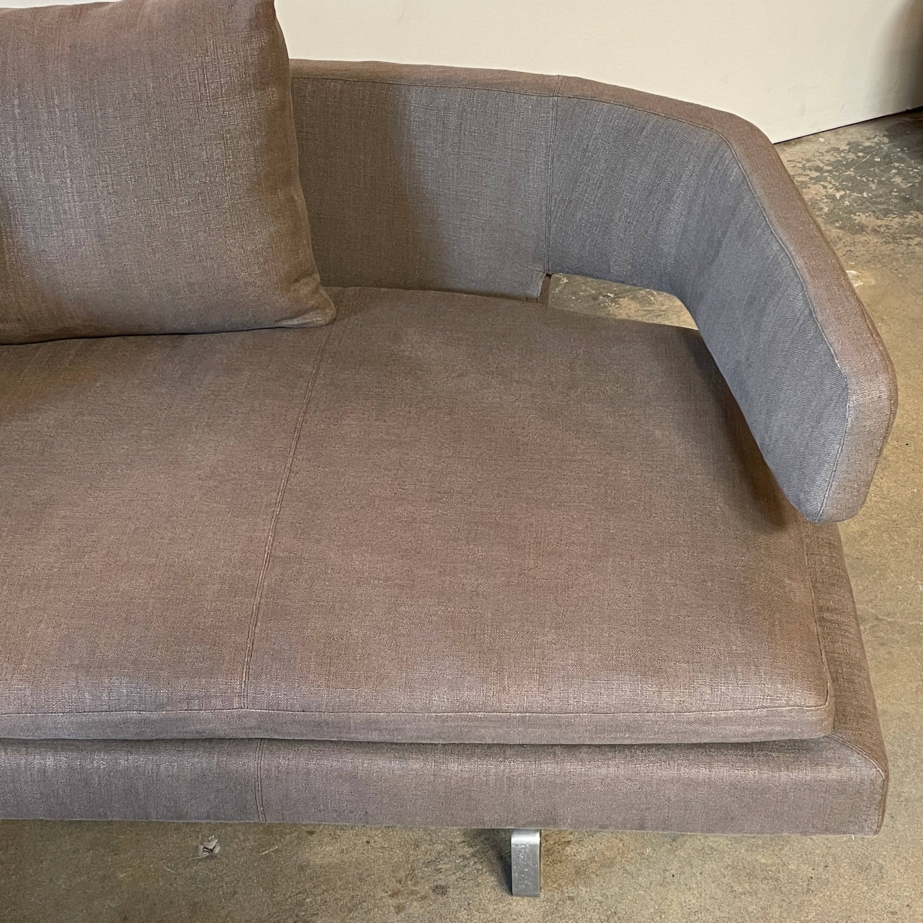 Modern upholstered l-shaped sectional B&B Italia Arne Sofa designed by Antonio Citterio, with cushions on a white background.