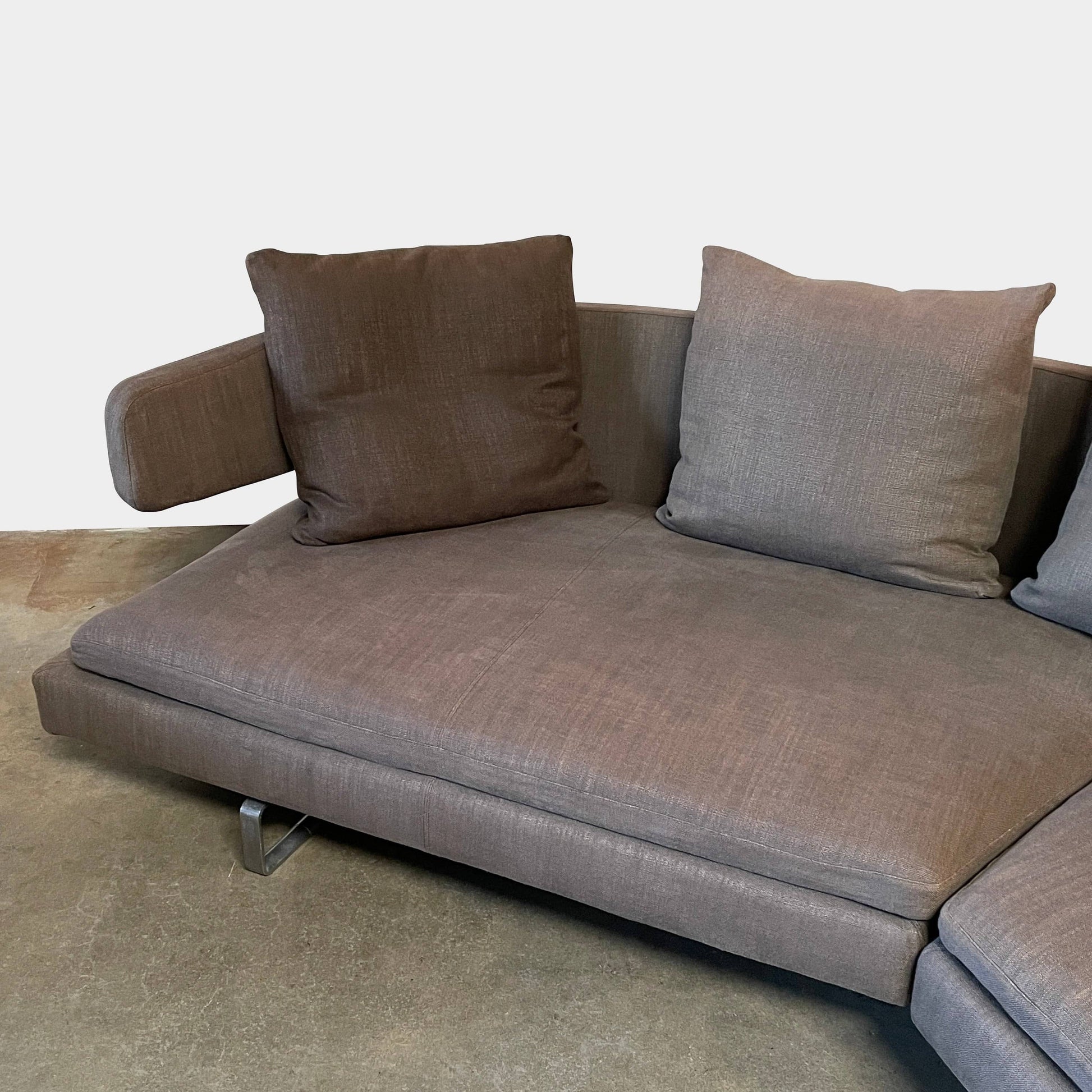 Modern upholstered l-shaped sectional B&B Italia Arne Sofa designed by Antonio Citterio, with cushions on a white background.