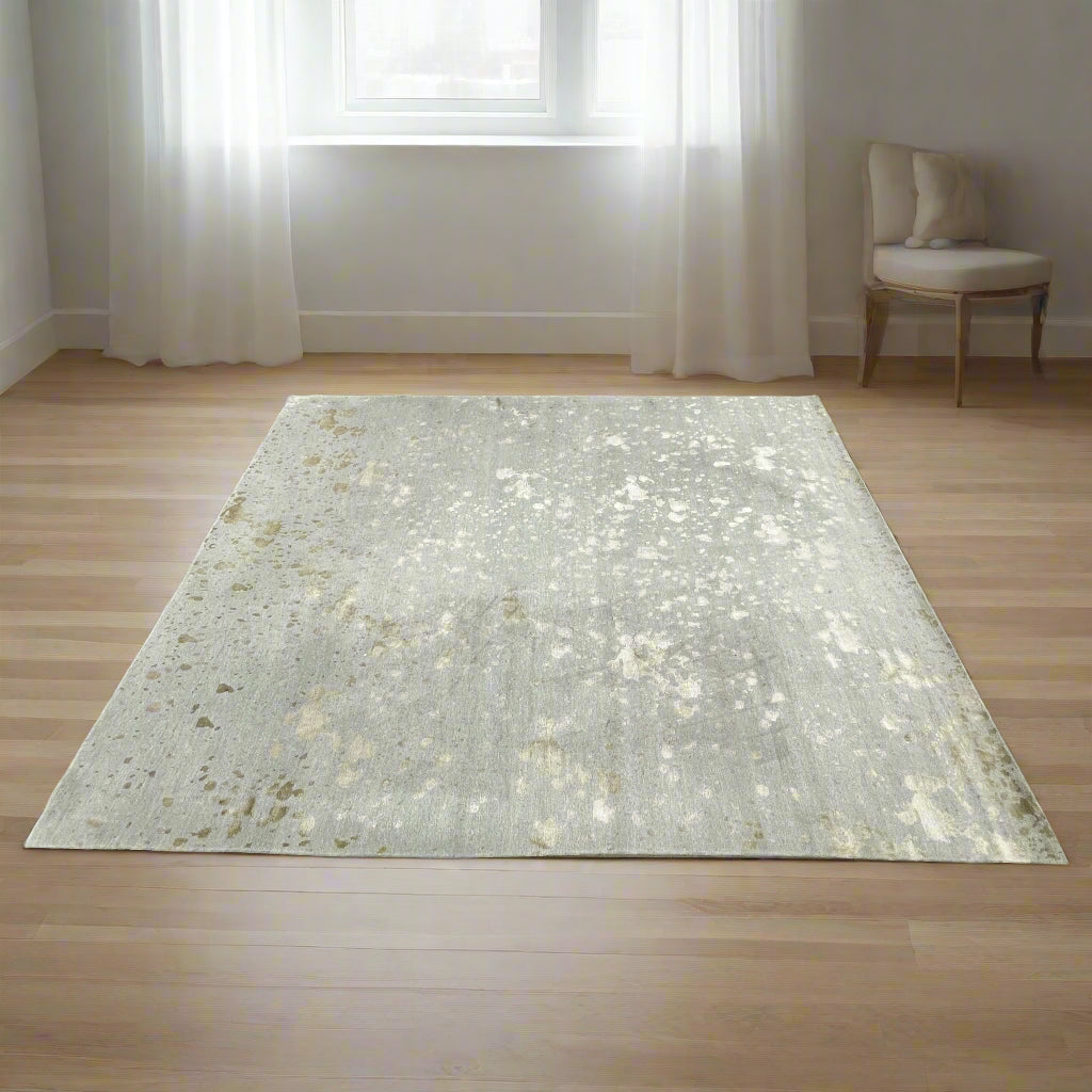 A section of the Delinear's 8 x 10 Delinier Splatter Rug features an abstract design with beige and gray spots, enhanced by Swiss Chromium Dye on Himalayan wool for vibrant detail.