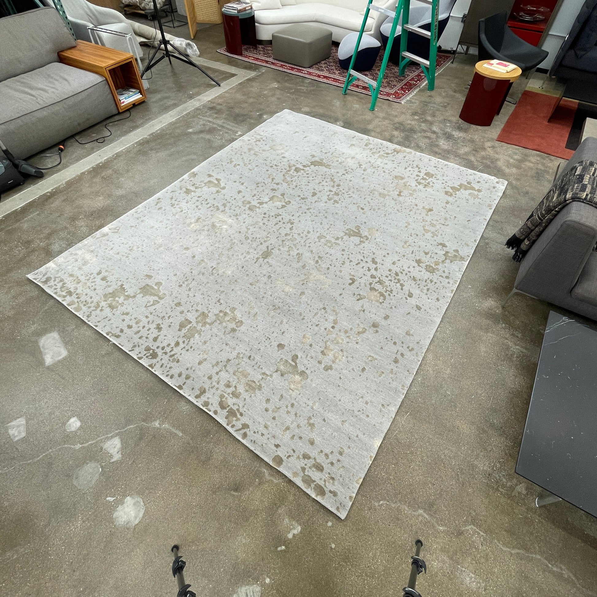A section of the Delinear's 8 x 10 Delinier Splatter Rug features an abstract design with beige and gray spots, enhanced by Swiss Chromium Dye on Himalayan wool for vibrant detail.