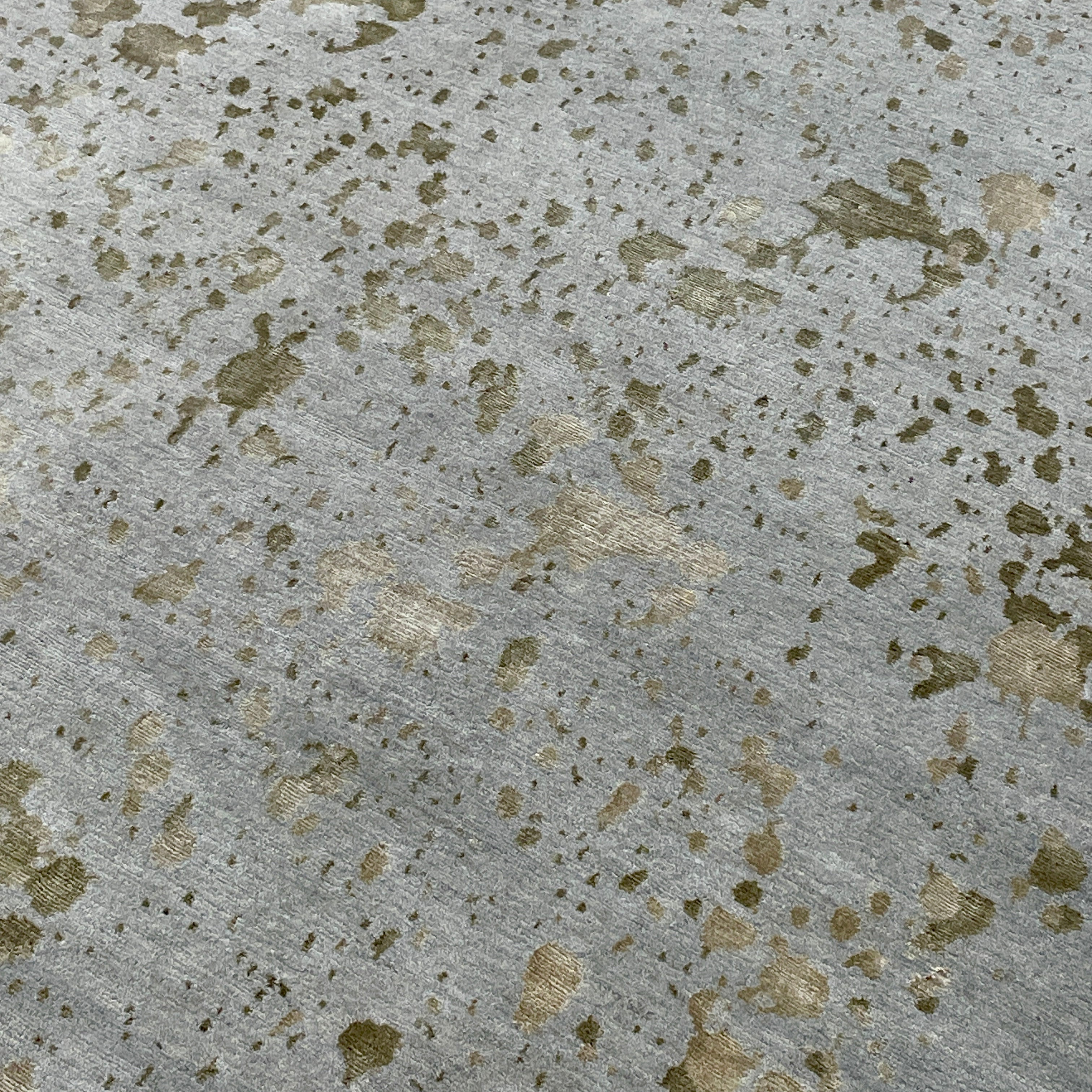 A section of the Delinear's 8 x 10 Delinier Splatter Rug features an abstract design with beige and gray spots, enhanced by Swiss Chromium Dye on Himalayan wool for vibrant detail.