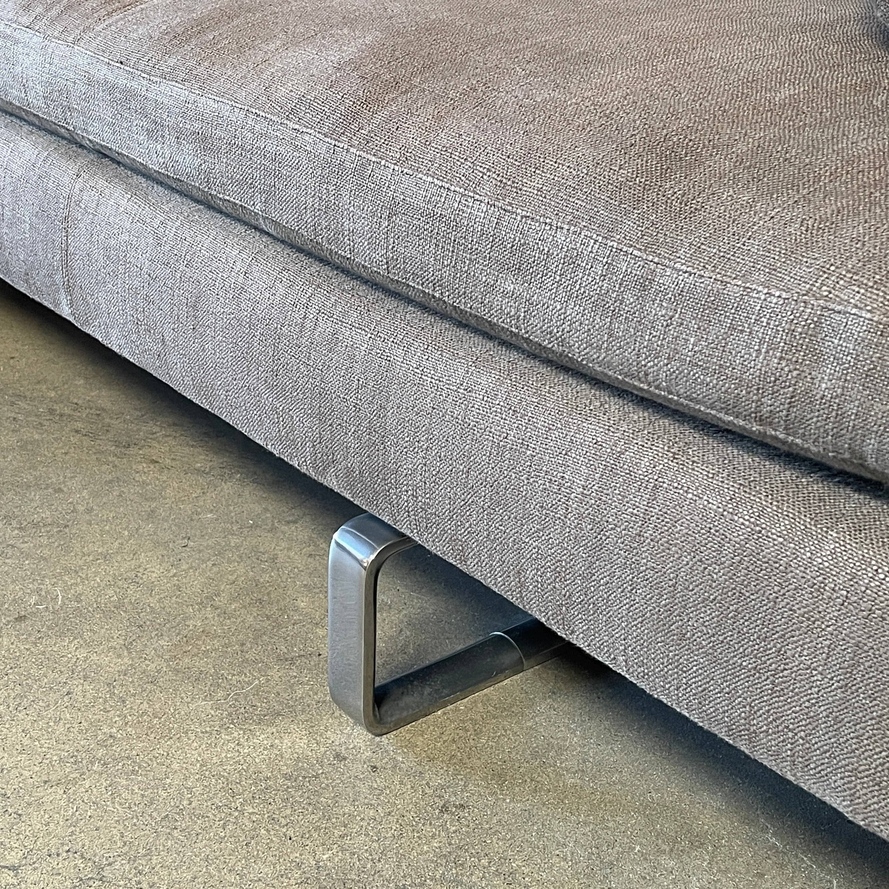 Modern upholstered l-shaped sectional B&B Italia Arne Sofa designed by Antonio Citterio, with cushions on a white background.