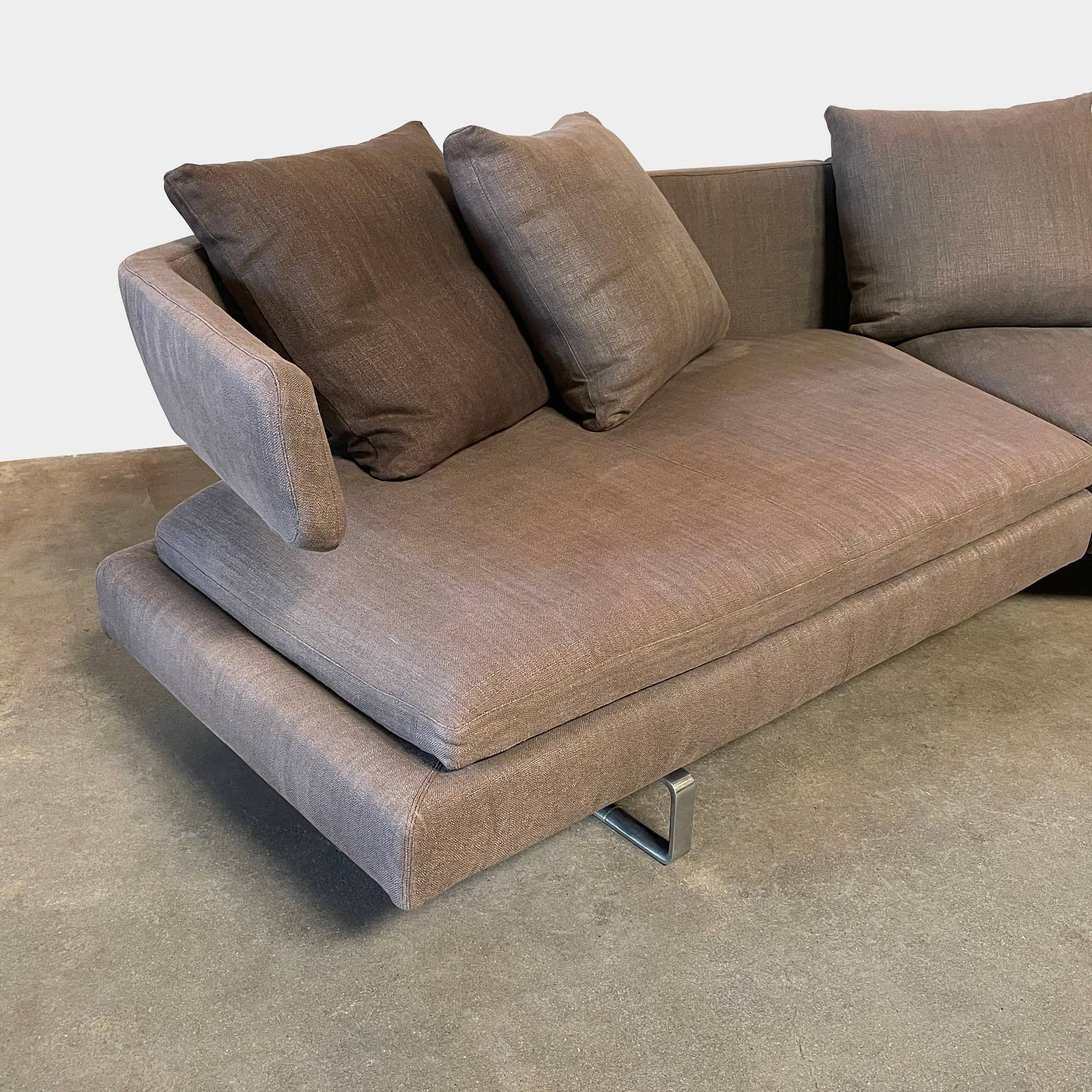 Modern upholstered l-shaped sectional B&B Italia Arne Sofa designed by Antonio Citterio, with cushions on a white background.