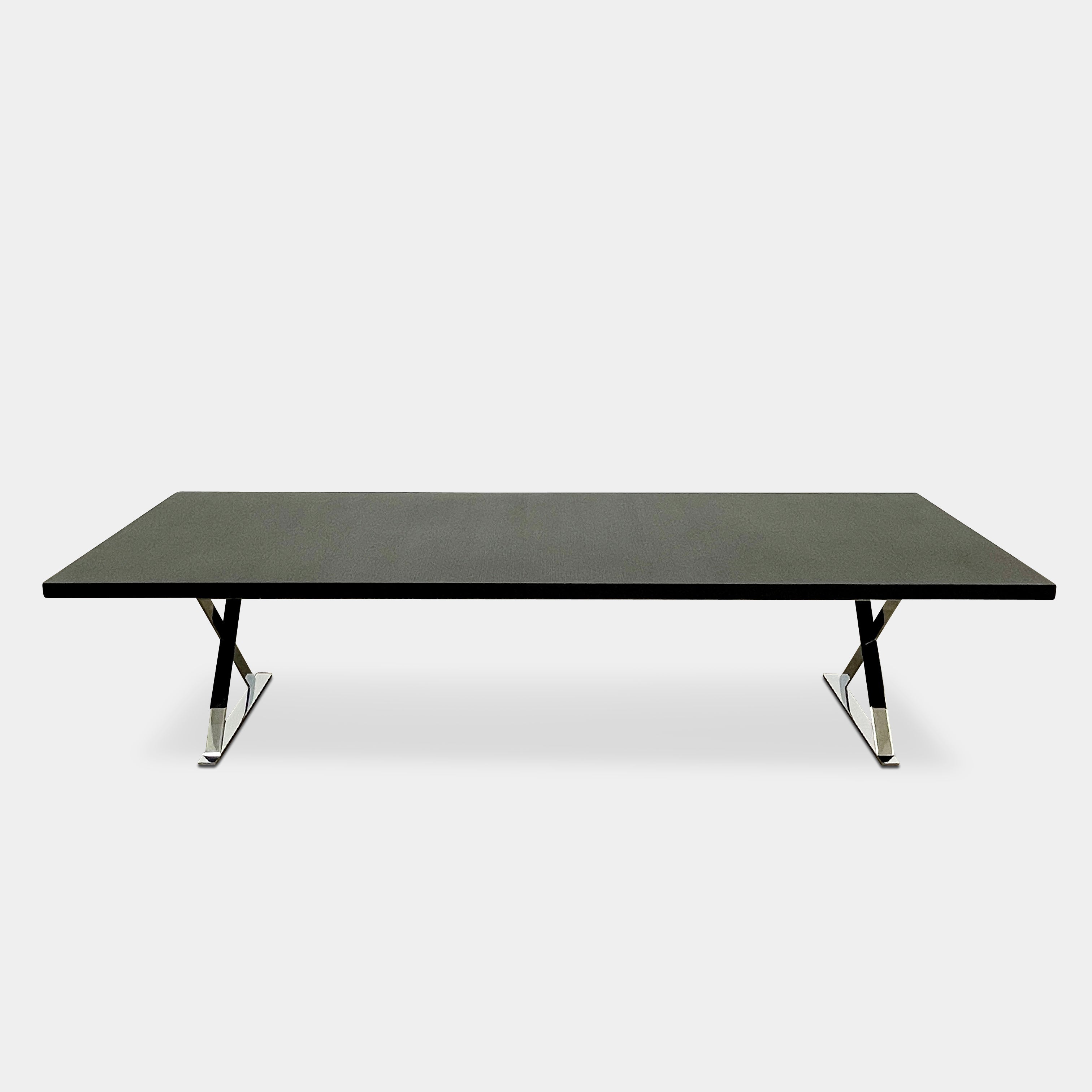 The Maxalto Max Dining Table by Maxalto is a minimalist black rectangular table made from brushed black oak, featuring a flat top with modern X-shaped metal legs.