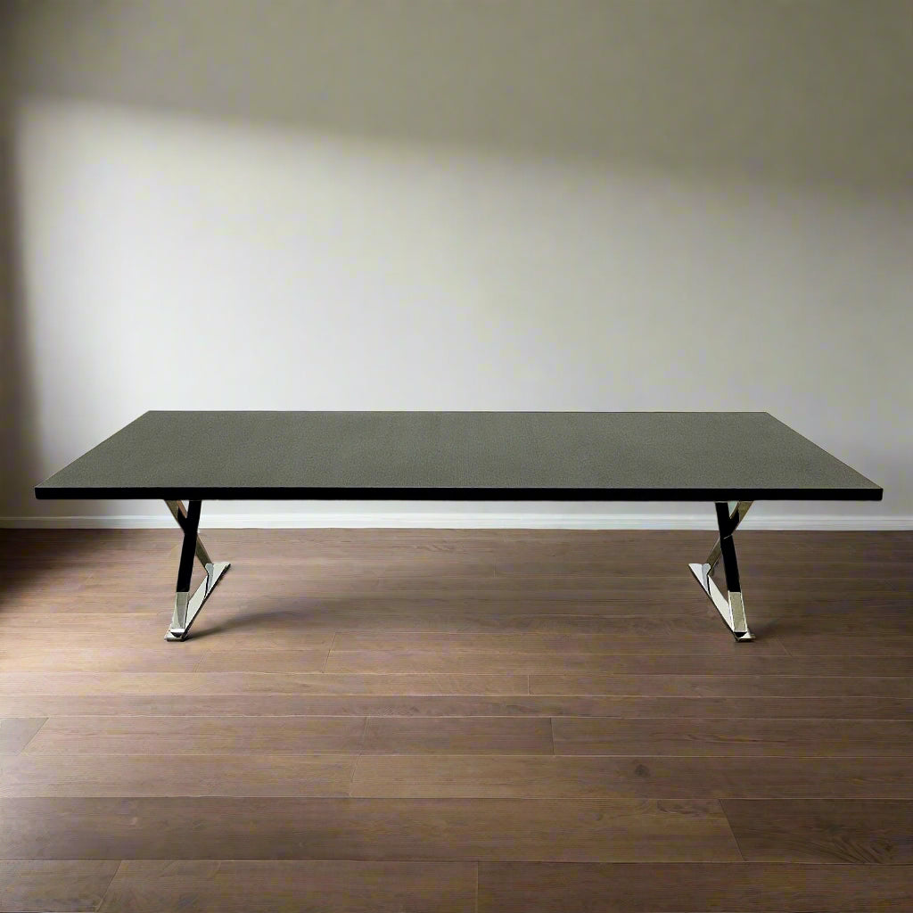 The Maxalto Max Dining Table by Maxalto is a minimalist black rectangular table made from brushed black oak, featuring a flat top with modern X-shaped metal legs.