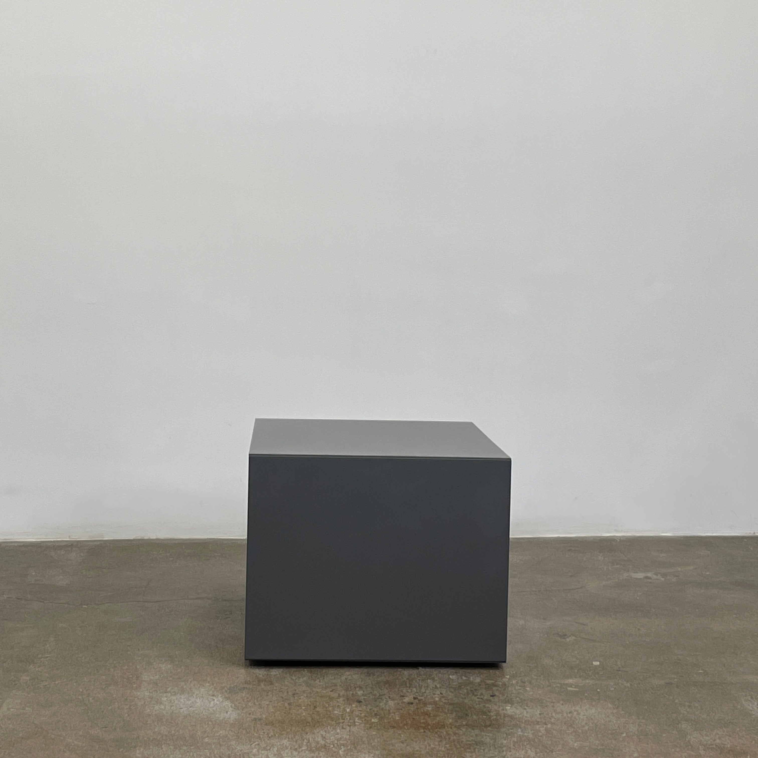 A rectangular gray and white lacquer box from B&B Italia, reminiscent of the Dado Night Table's minimalist design, features a glossy upper and matte lower section. This sleek piece serves as a stylish bedside companion, enhancing any modern space against a plain white background.