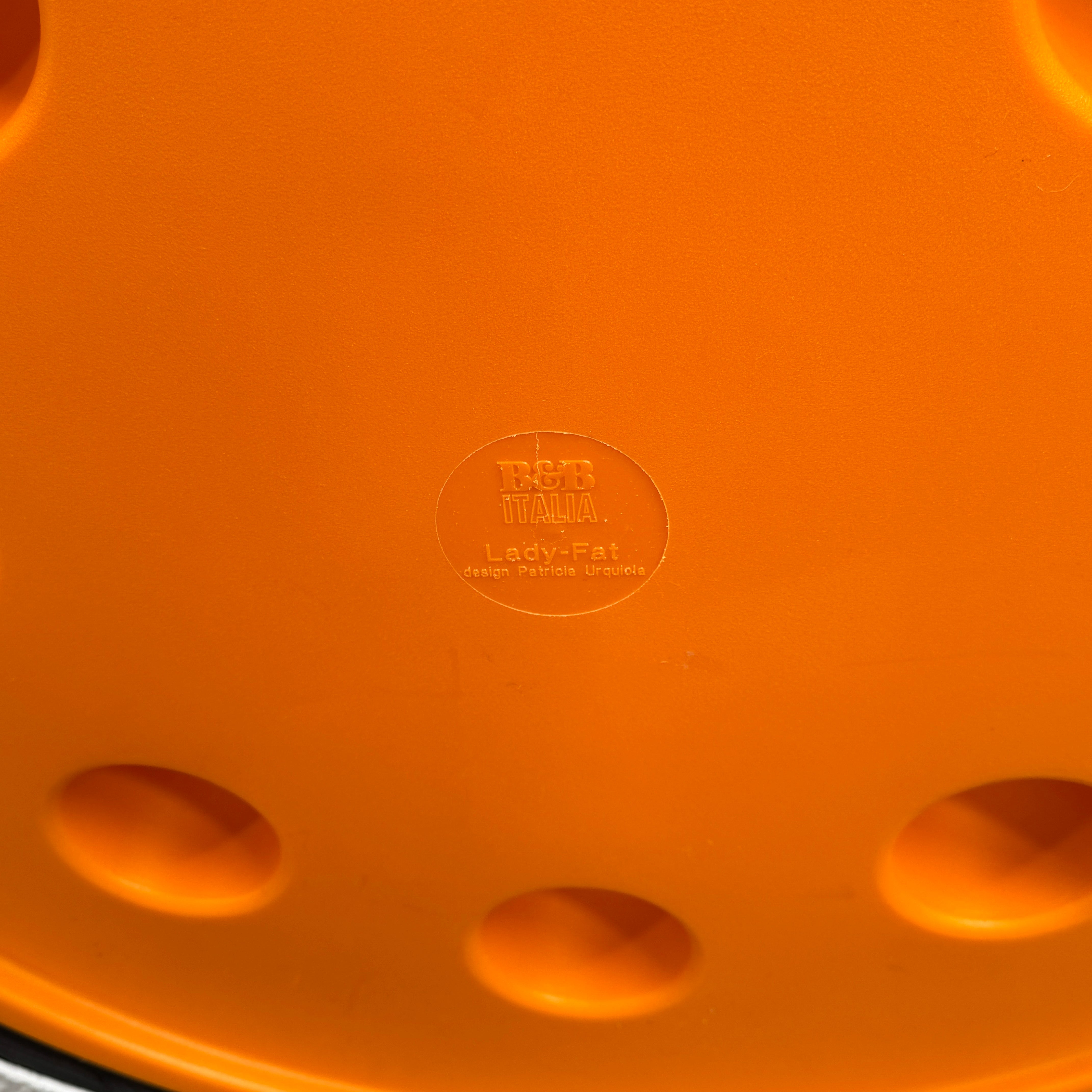 The B&B Italia Lady Fat Coffee Table by B&B Italia, a low, round table with a flat white top inspired by Patricia Urquiola’s design, sits on a plain brown floor against a light gray wall.