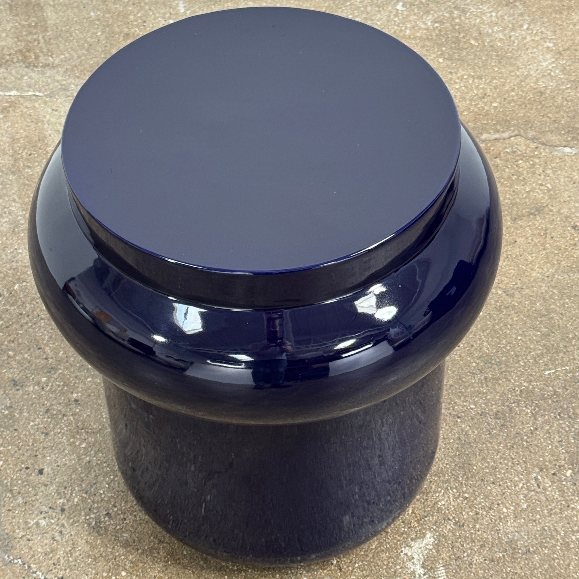 The Delcourt Collection Dot table by Delcourt Collection, designed by Charles Kalpakian, features a glossy ultramarine blue glaze and a dark blue cylindrical form with a wide, rounded top edge, set against a plain white background.
