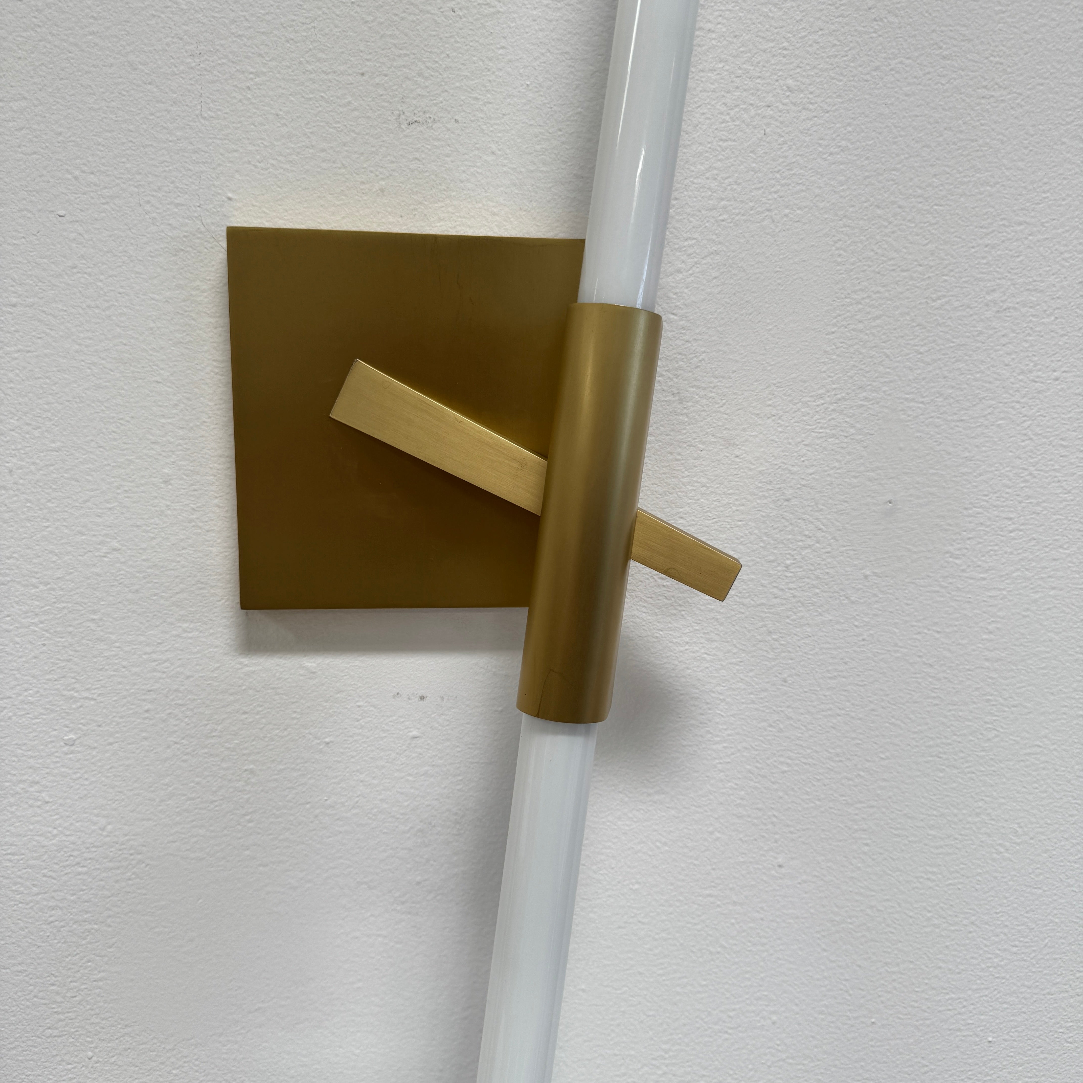 The Roll & Hill Agnes Wall Sconces (Set of 2) feature vertical cylindrical white fixtures on square brass bases with geometric and angled brass accents for a modern look.