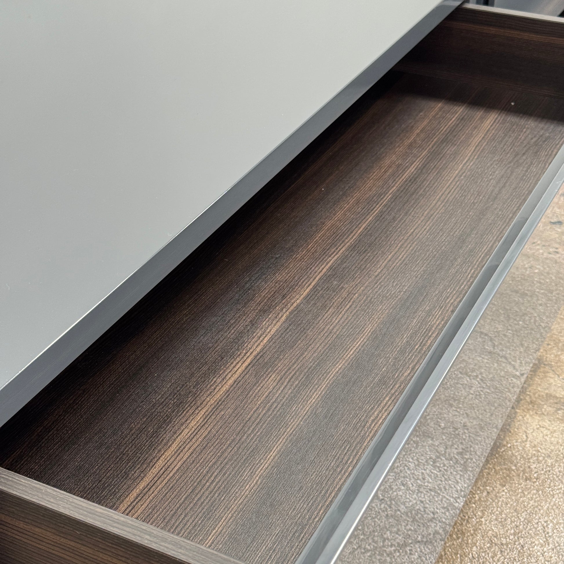 A pair of Poliform Dream Night Stands, each dark and rectangular with three drawers, stand side by side on a concrete floor against a plain white wall.