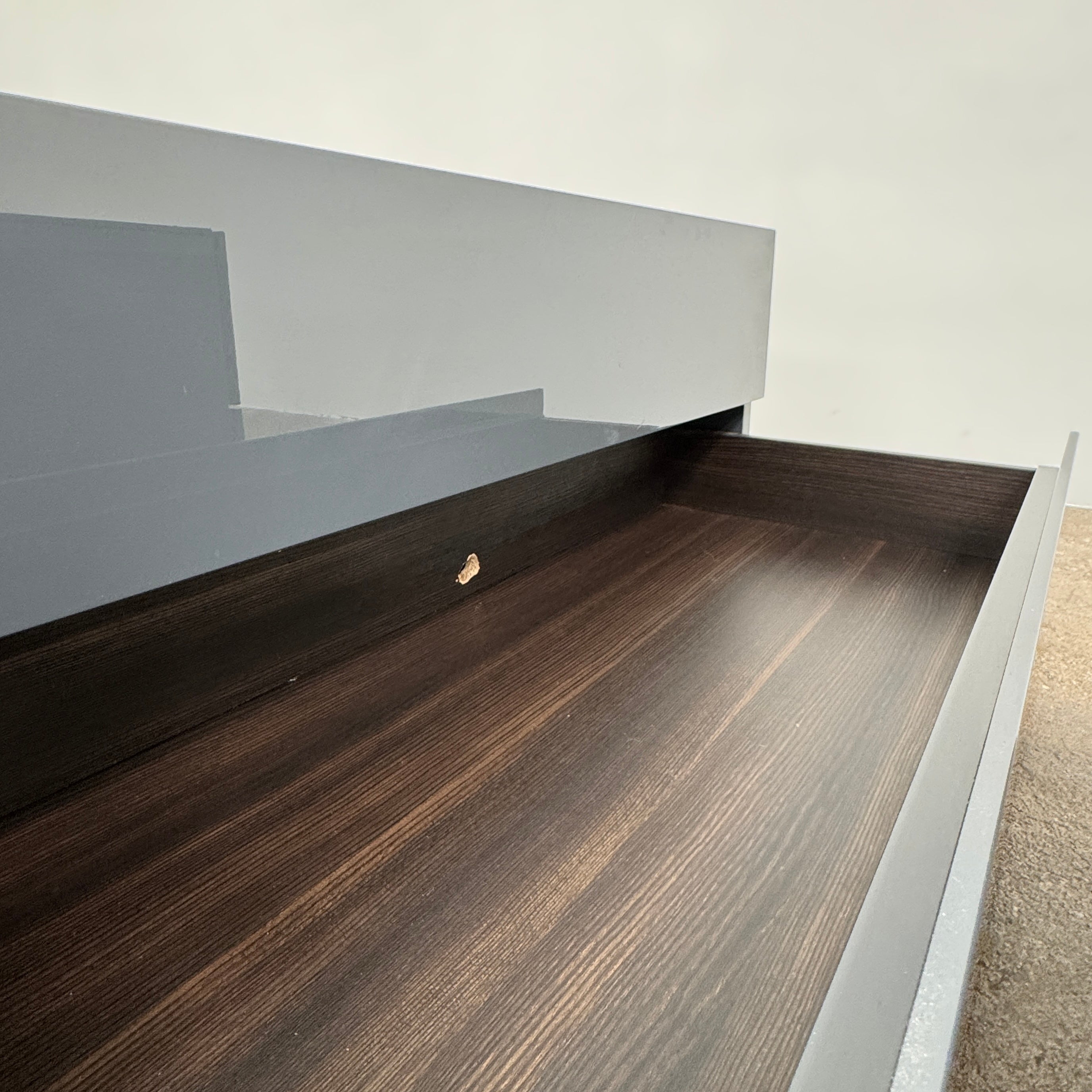 A pair of Poliform Dream Night Stands, each dark and rectangular with three drawers, stand side by side on a concrete floor against a plain white wall.