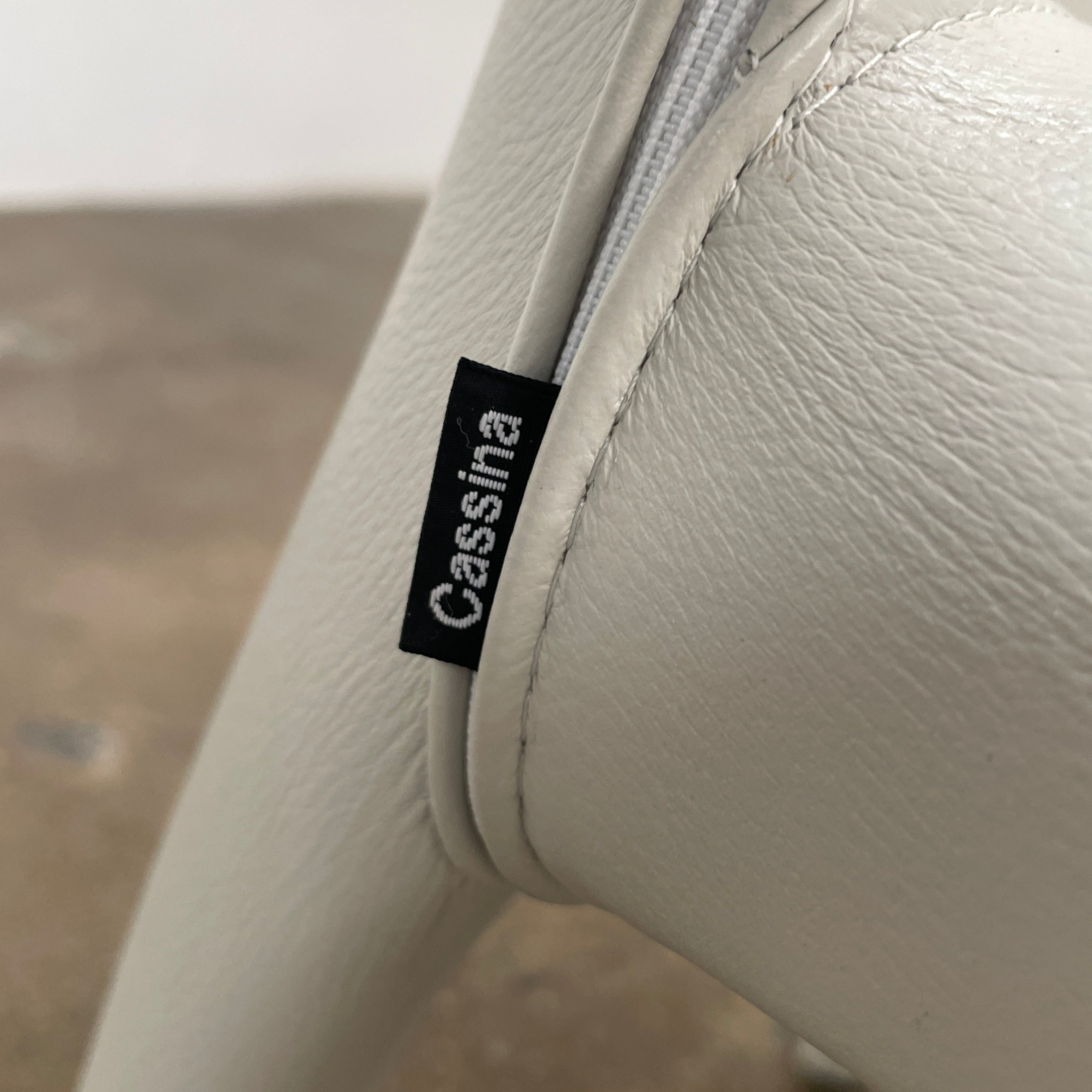 Six Cassina Hola 367 Dining Chairs, identical and upholstered in white leather, are elegantly arranged in two rows on a plain background.