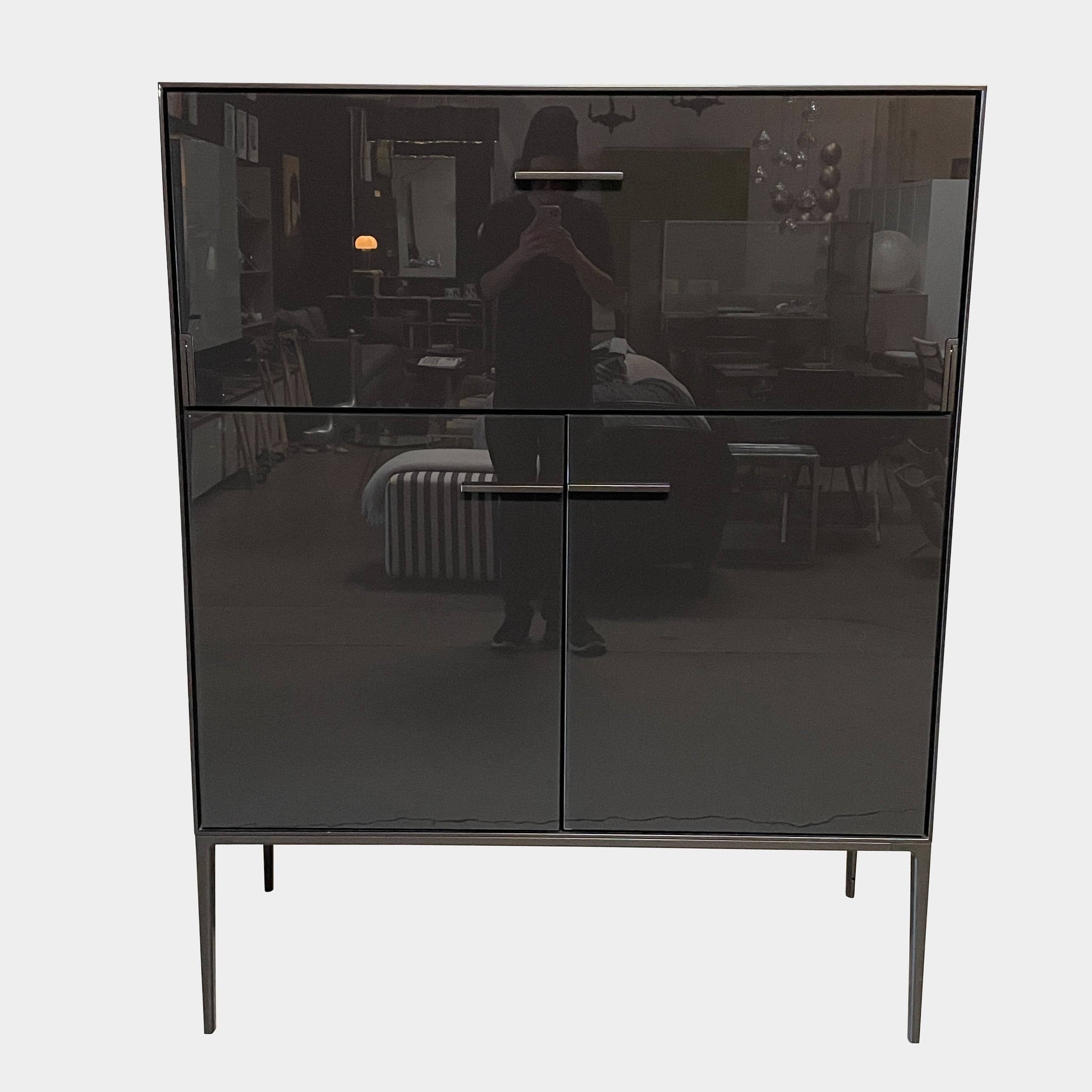 The B&B Italia Eucalipto Living Storage Unit is a sleek black metal cabinet with one drawer, two doors, and slim legs. It offers a minimalist and modern design, perfect for sophisticated bar storage.
