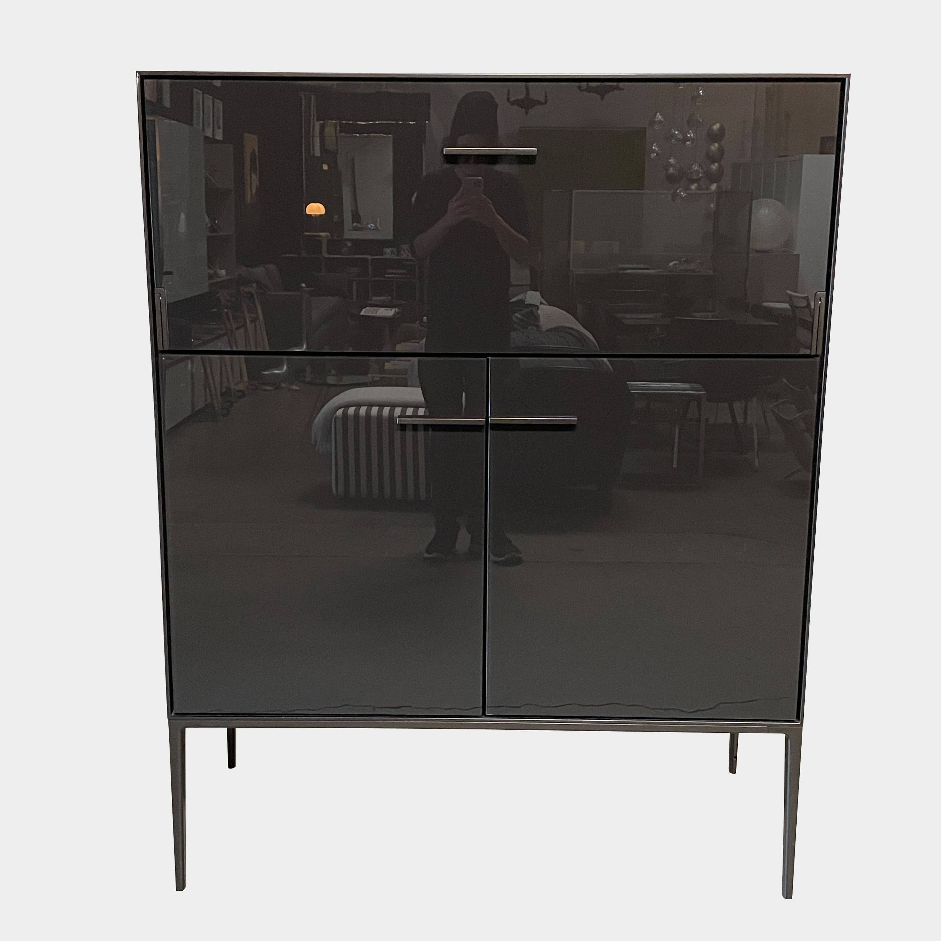 The B&B Italia Eucalipto Living Storage Unit is a sleek black metal cabinet with one drawer, two doors, and slim legs. It offers a minimalist and modern design, perfect for sophisticated bar storage.