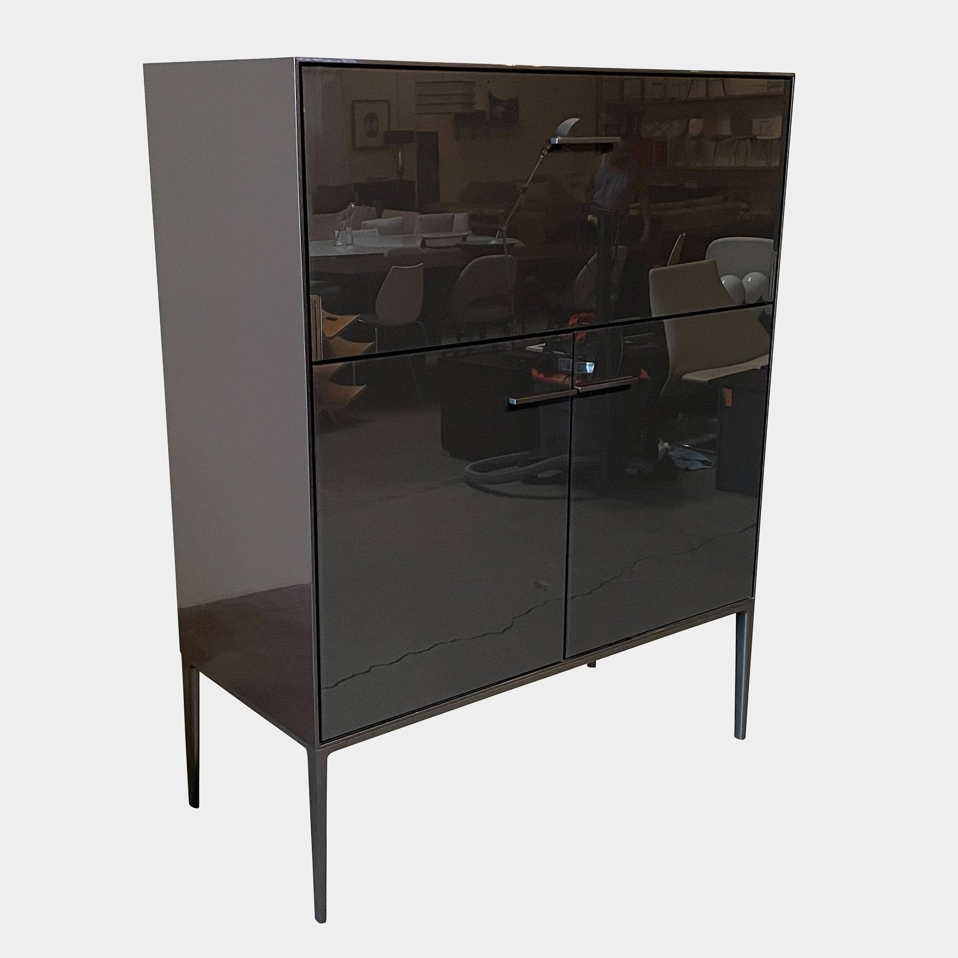 The B&B Italia Eucalipto Living Storage Unit is a sleek black metal cabinet with one drawer, two doors, and slim legs. It offers a minimalist and modern design, perfect for sophisticated bar storage.