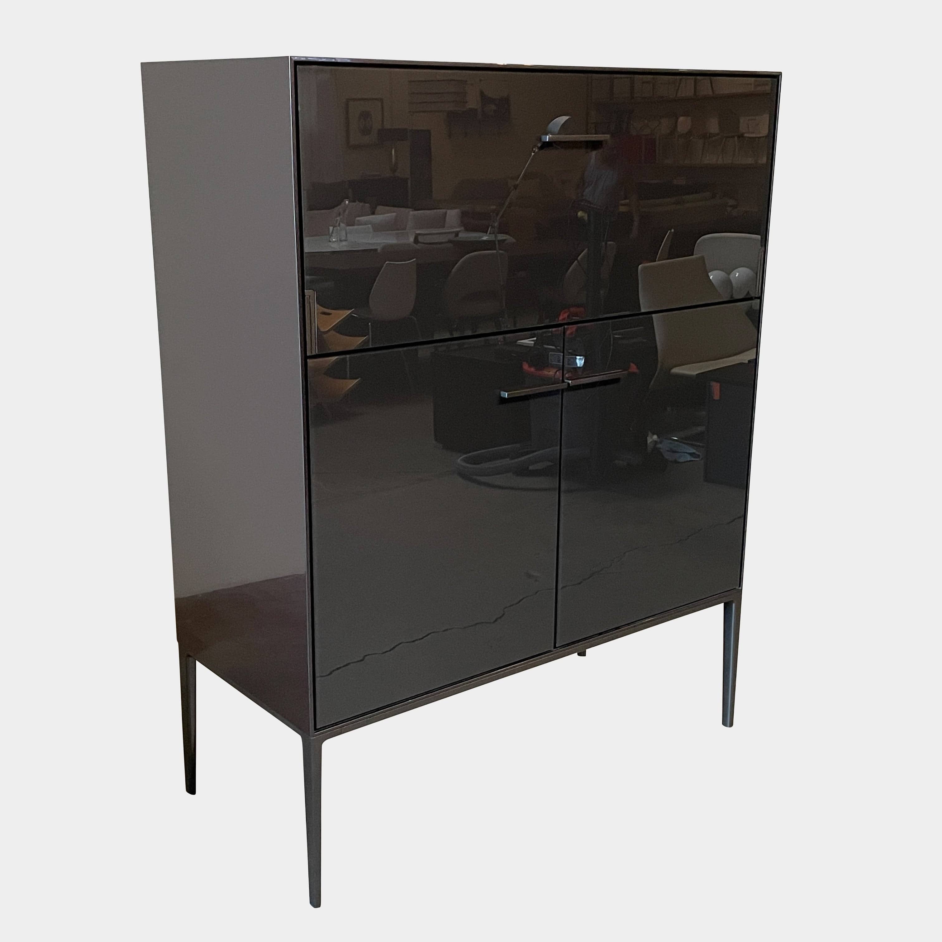 The B&B Italia Eucalipto Living Storage Unit is a sleek black metal cabinet with one drawer, two doors, and slim legs. It offers a minimalist and modern design, perfect for sophisticated bar storage.