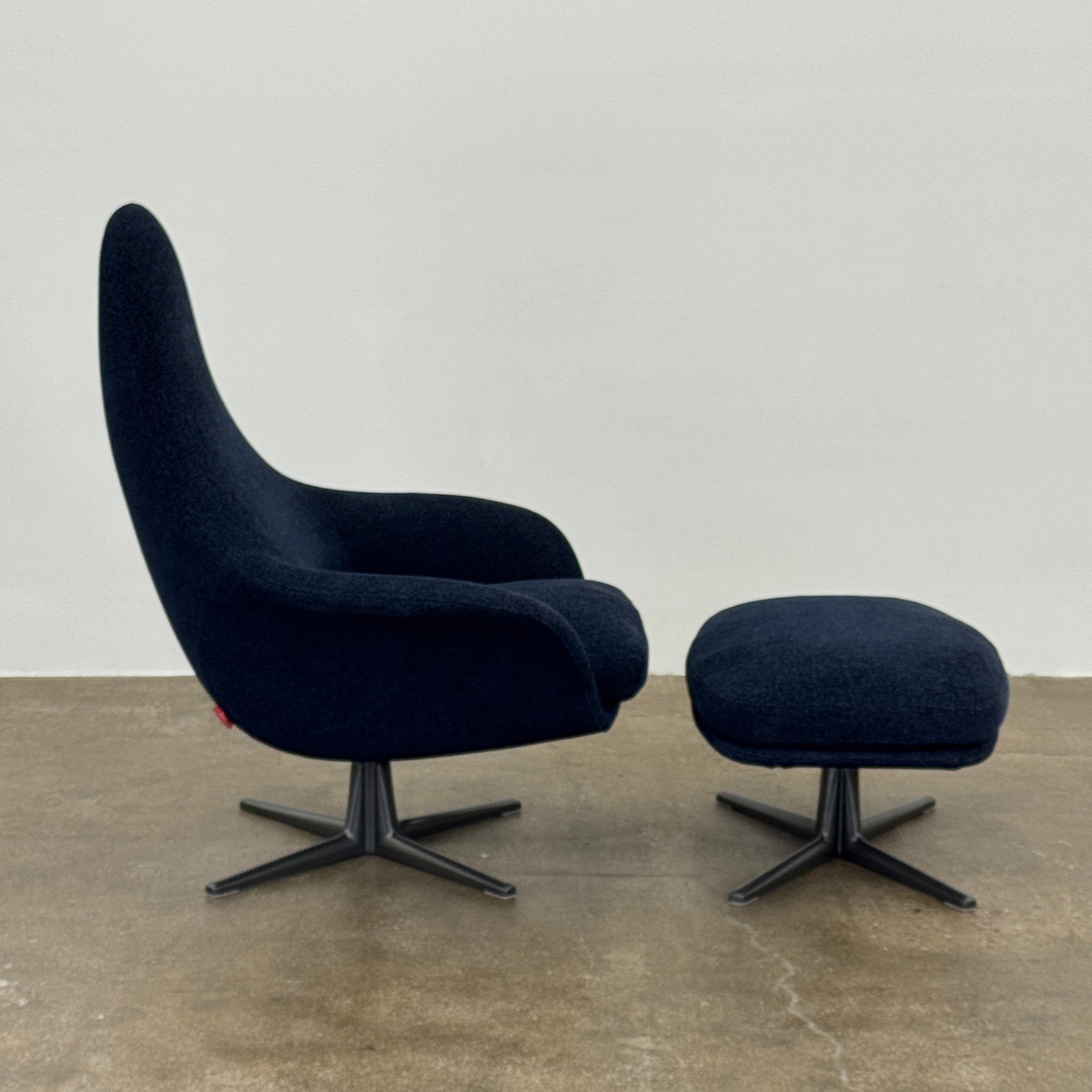 The Flexform Marlon Swivel Armchair and Ottoman, available with two covers, feature ergonomic design and black metal bases from Flexform, shown here in a modern gray finish against a plain white background.