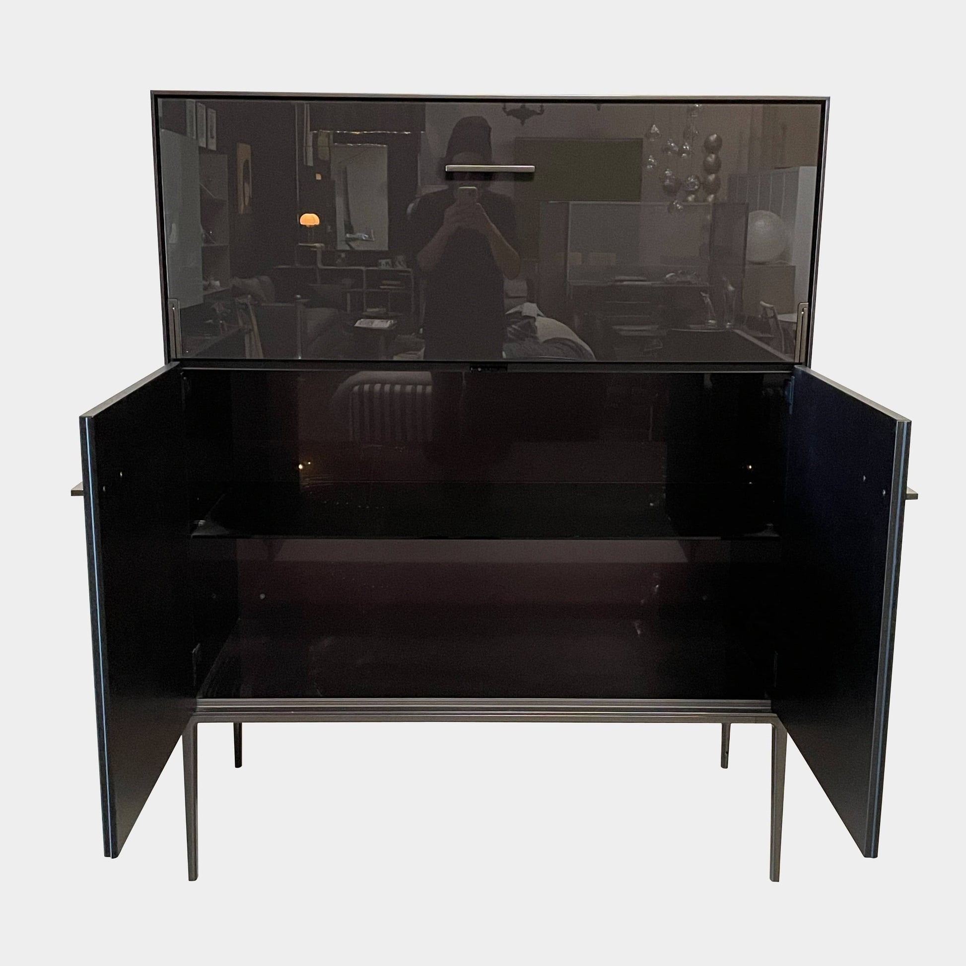 The B&B Italia Eucalipto Living Storage Unit is a sleek black metal cabinet with one drawer, two doors, and slim legs. It offers a minimalist and modern design, perfect for sophisticated bar storage.