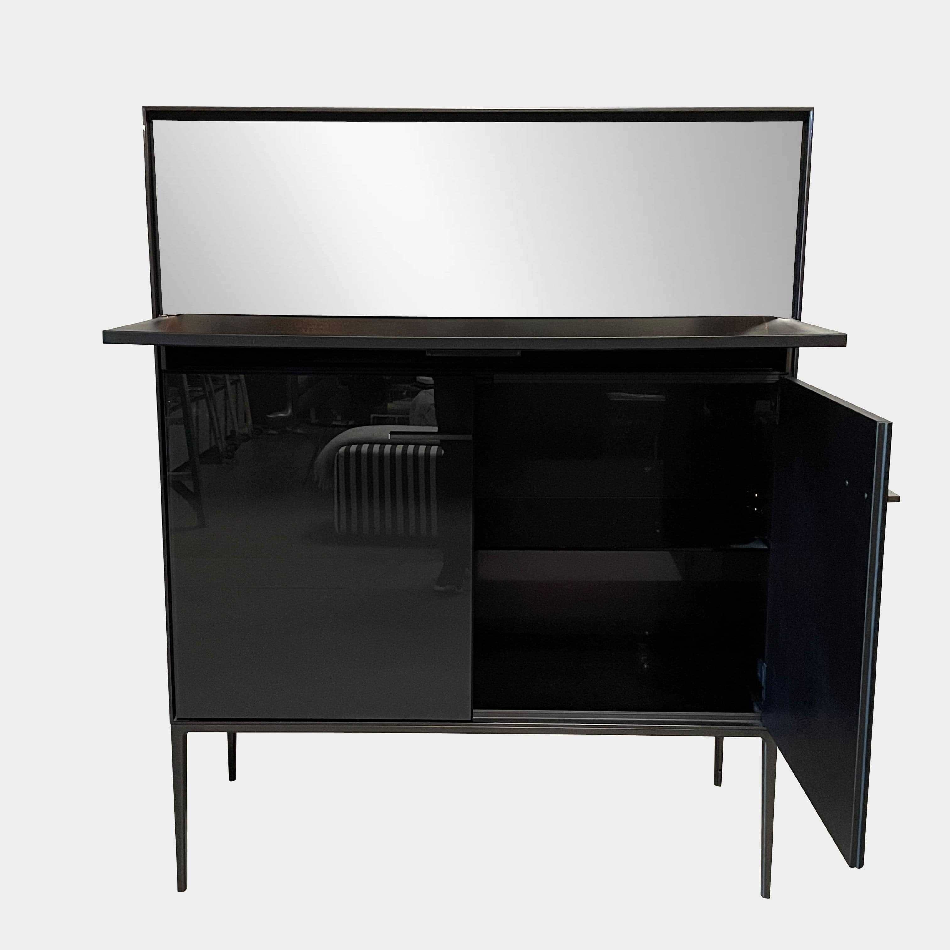 The B&B Italia Eucalipto Living Storage Unit is a sleek black metal cabinet with one drawer, two doors, and slim legs. It offers a minimalist and modern design, perfect for sophisticated bar storage.