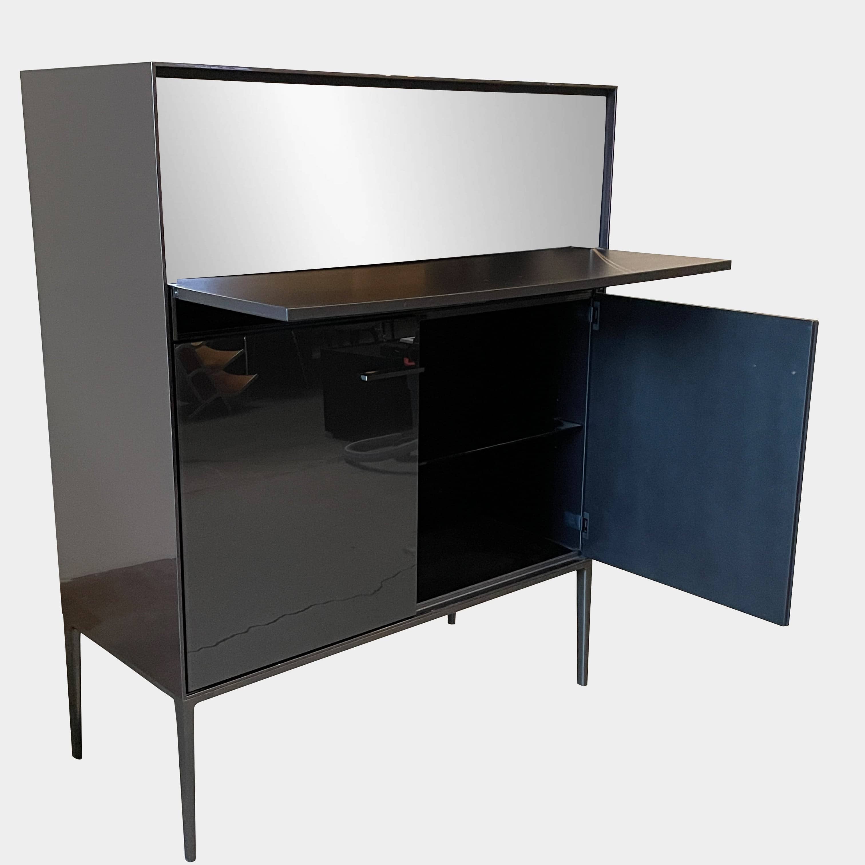 The B&B Italia Eucalipto Living Storage Unit is a sleek black metal cabinet with one drawer, two doors, and slim legs. It offers a minimalist and modern design, perfect for sophisticated bar storage.