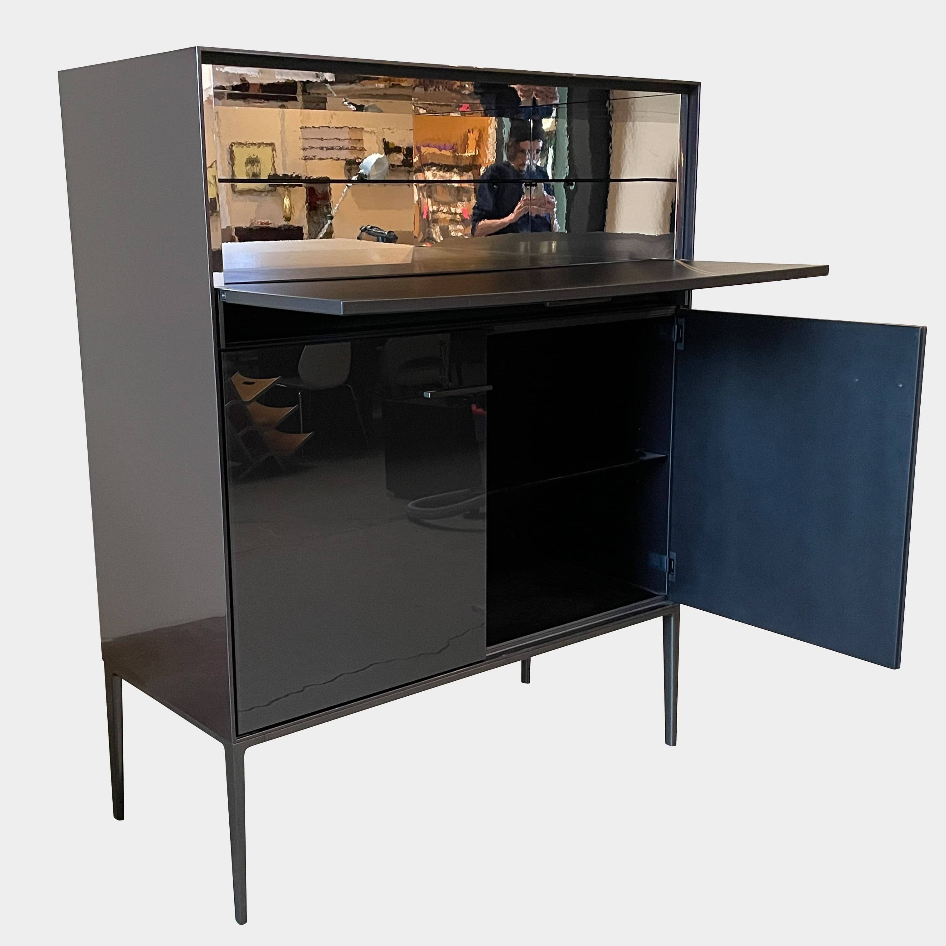 The B&B Italia Eucalipto Living Storage Unit is a sleek black metal cabinet with one drawer, two doors, and slim legs. It offers a minimalist and modern design, perfect for sophisticated bar storage.