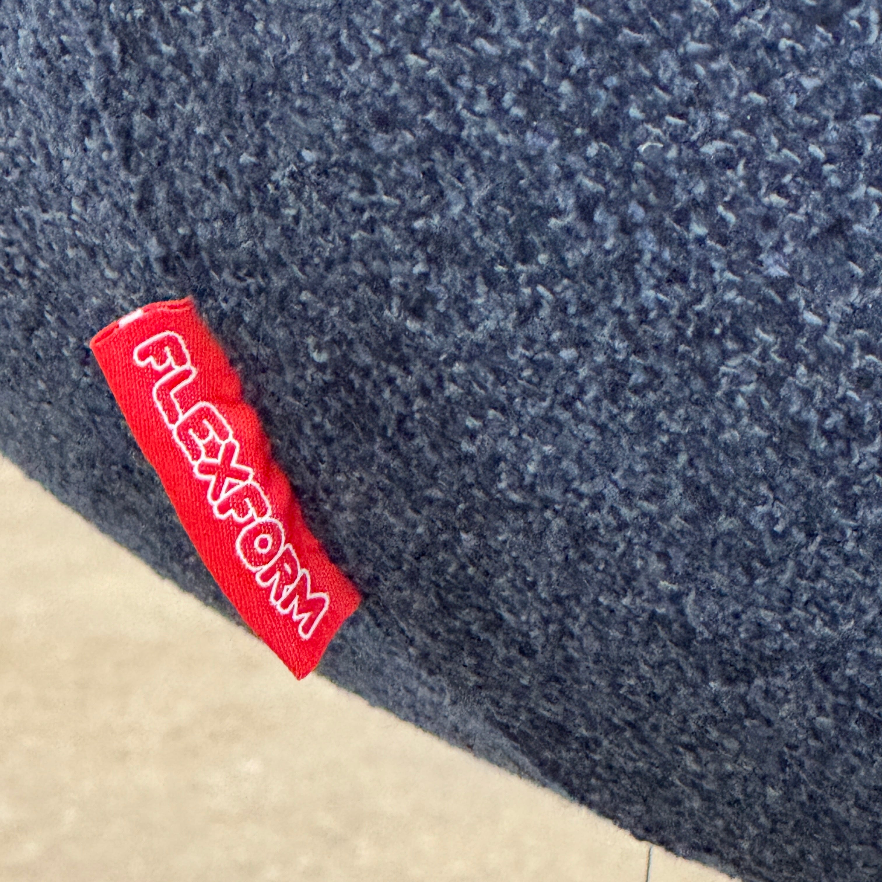 The Flexform Marlon Swivel Armchair and Ottoman, available with two covers, feature ergonomic design and black metal bases from Flexform, shown here in a modern gray finish against a plain white background.