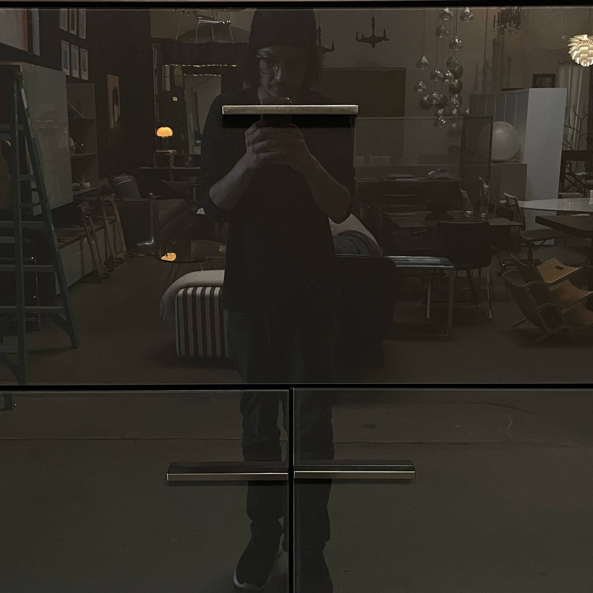 The B&B Italia Eucalipto Living Storage Unit is a sleek black metal cabinet with one drawer, two doors, and slim legs. It offers a minimalist and modern design, perfect for sophisticated bar storage.