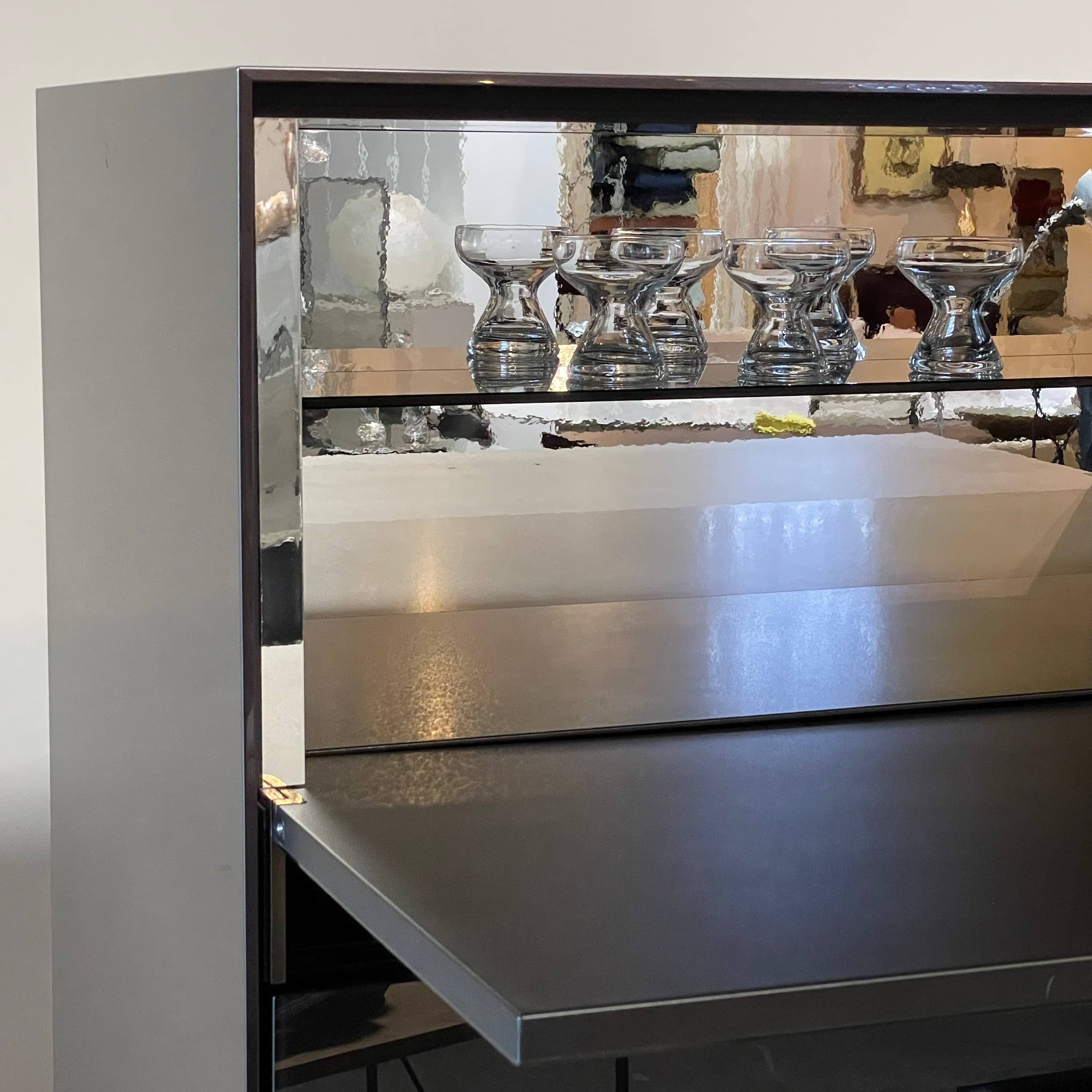 The B&B Italia Eucalipto Living Storage Unit is a sleek black metal cabinet with one drawer, two doors, and slim legs. It offers a minimalist and modern design, perfect for sophisticated bar storage.