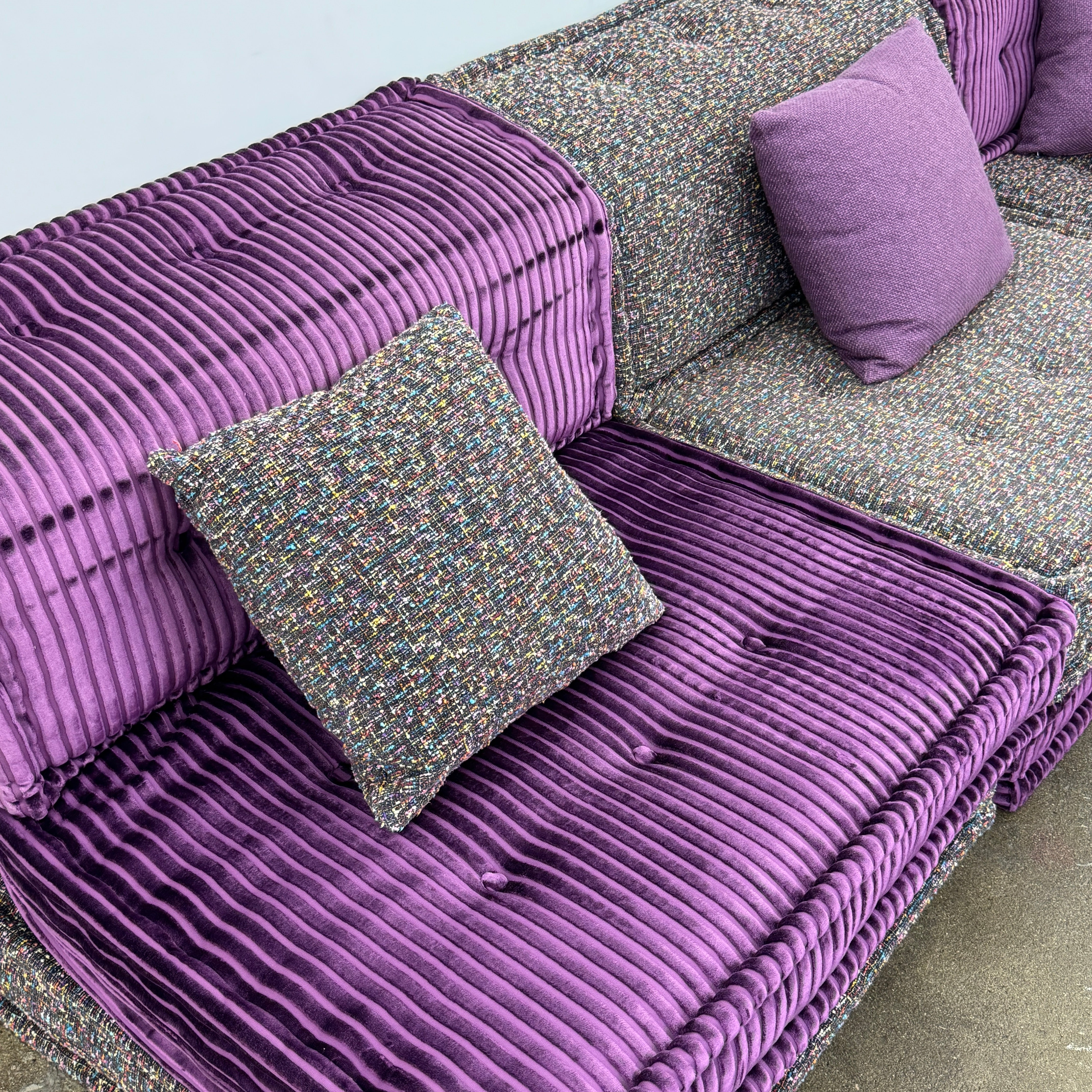 The Roche Bobois Mah Jong Sectional - Back with Mechanism by Roche Bobois features a modern modular design, purple and gray corduroy upholstery, and includes two purple throw pillows, inspired by the iconic Mah Jong sofa.