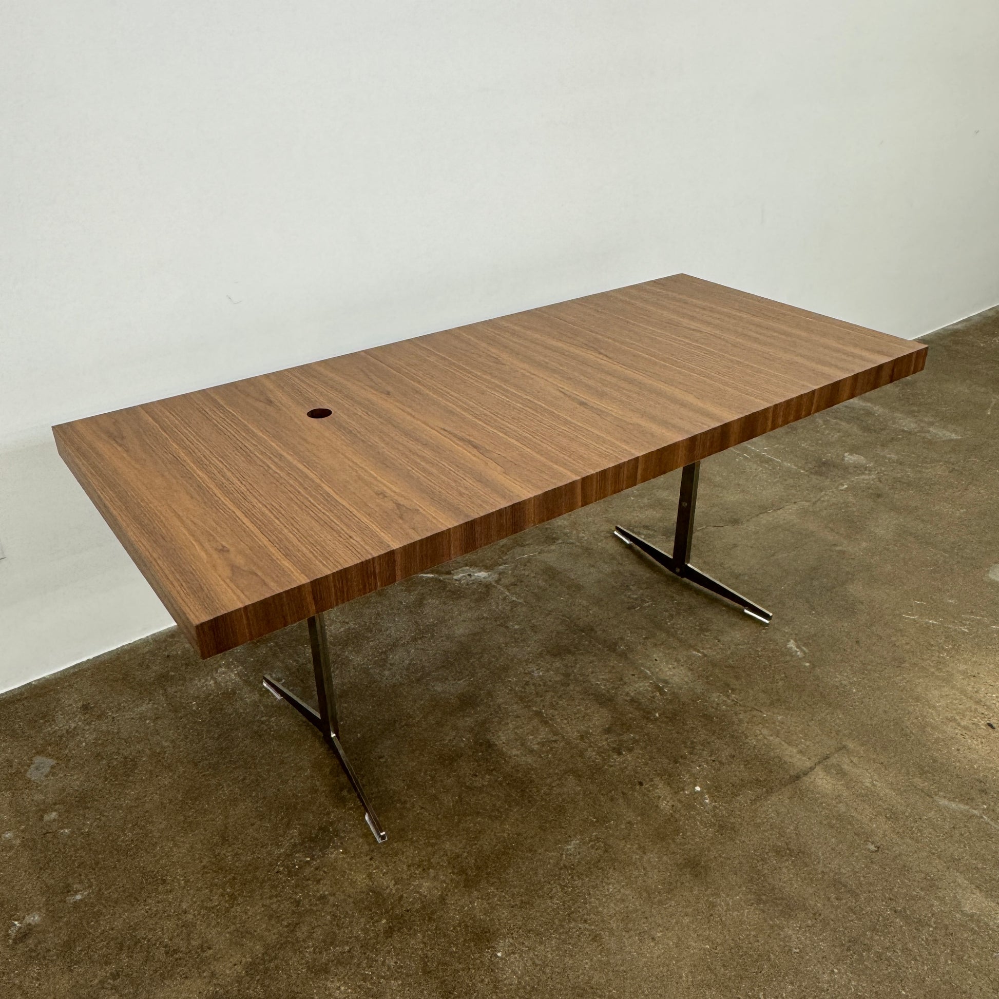 The Flexform Fly Canaletto Walnut Desk is a custom wood desk with a central circular cable management hole, reflecting the refined style of Flexform.