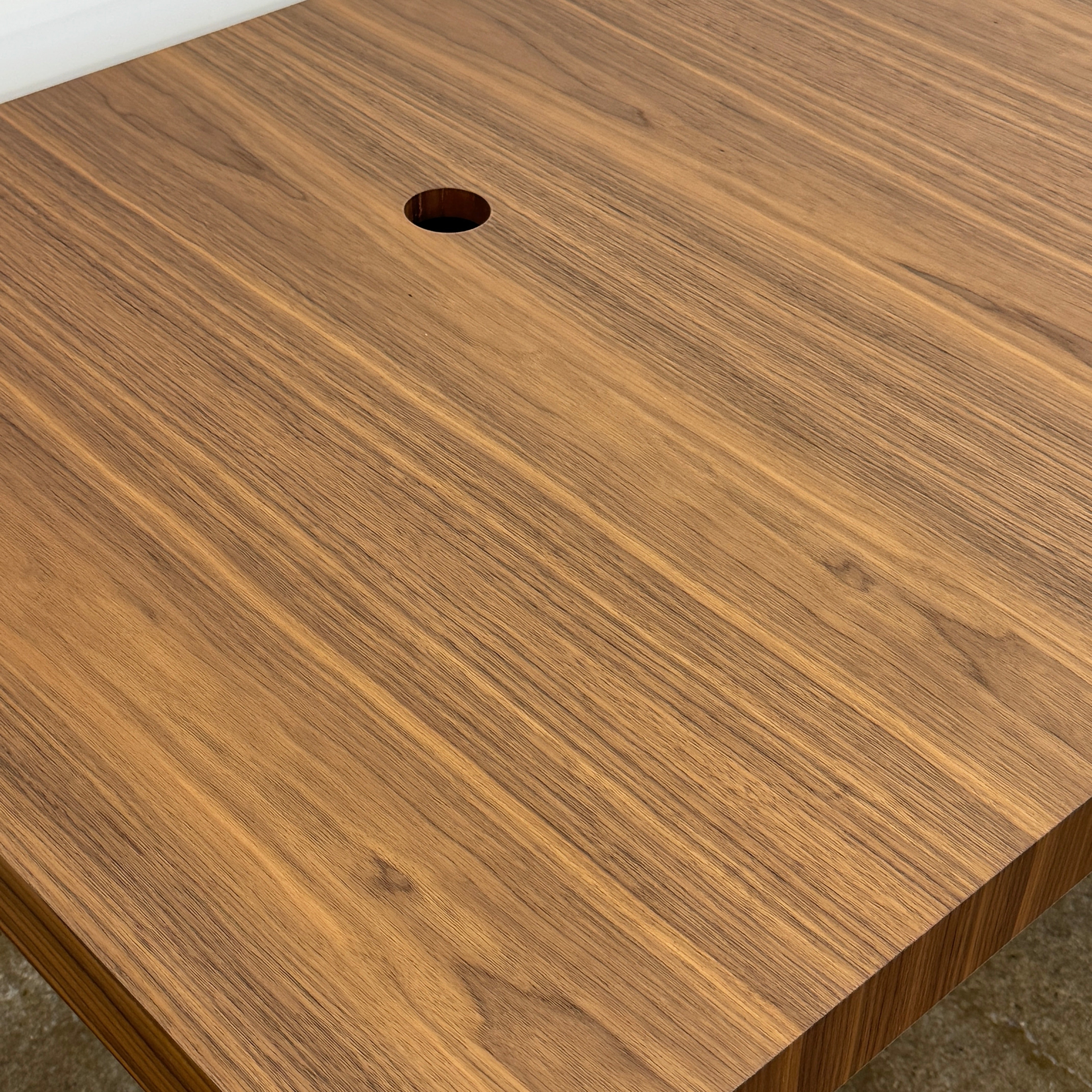 The Flexform Fly Canaletto Walnut Desk is a custom wood desk with a central circular cable management hole, reflecting the refined style of Flexform.