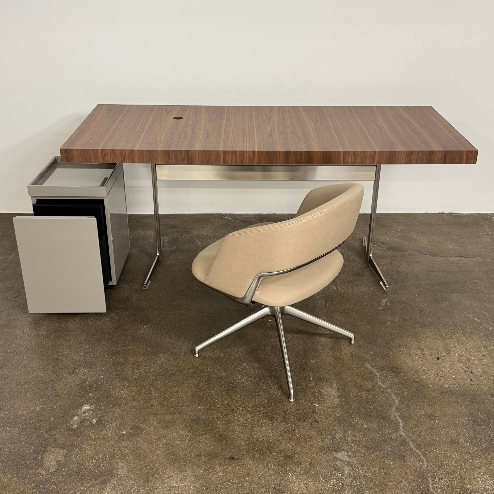 The Flexform Fly Canaletto Walnut Desk is a custom wood desk with a central circular cable management hole, reflecting the refined style of Flexform.