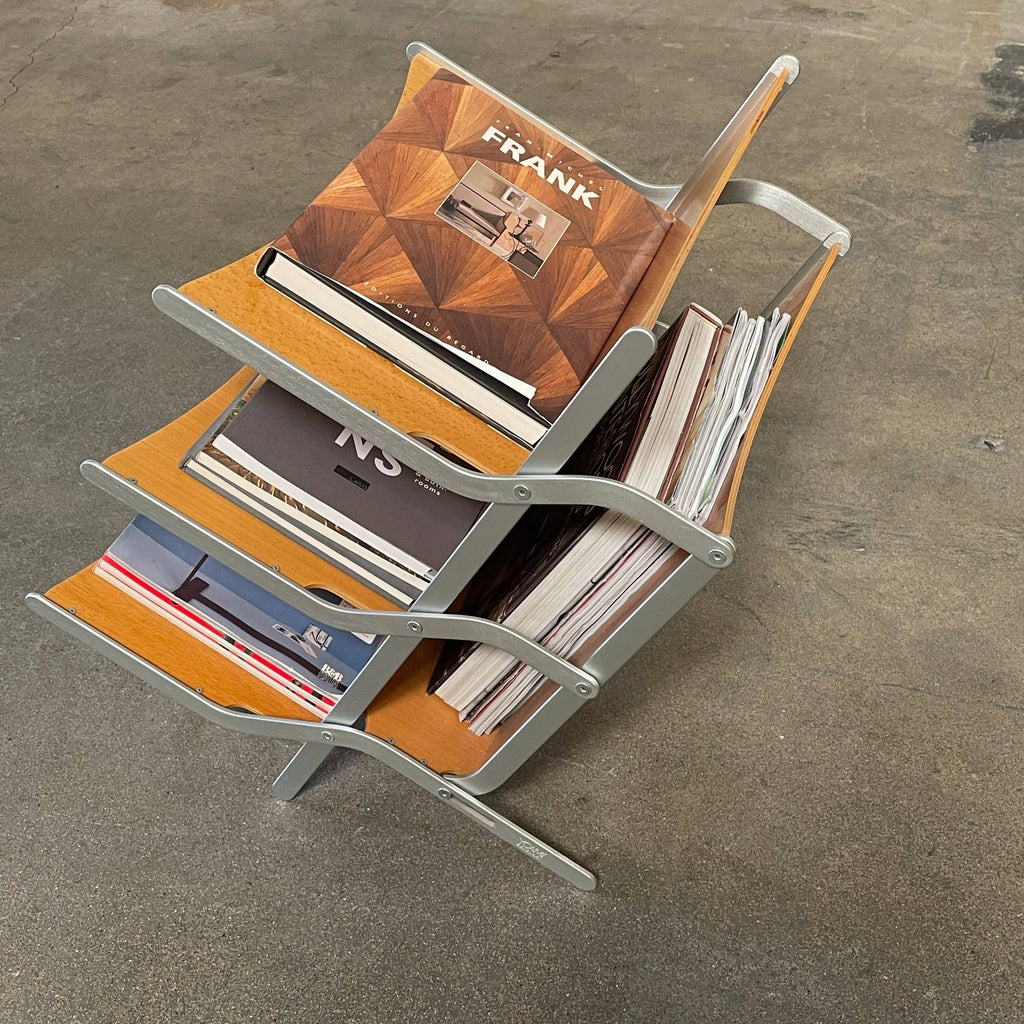 A stack of books on a YCAMI Press folding magazine rack.
