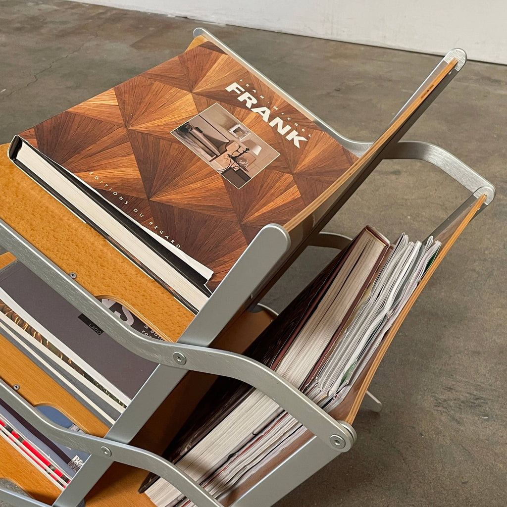 A stack of books on a YCAMI Press folding magazine rack.
