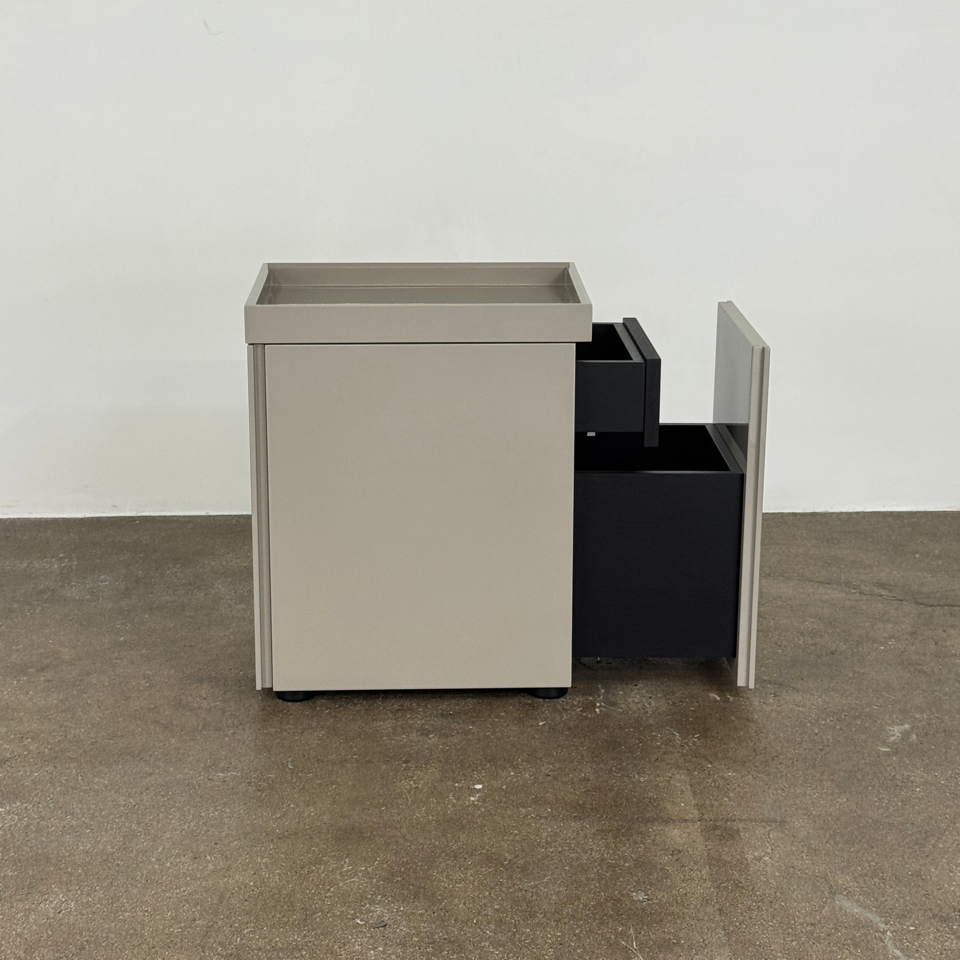 A Rev-A-Shelf instruction sheet and a "100% Thought&Made in Italy" leaflet sit on two beige trays, ideal for organizing your workspace or pairing with the Flexform Benjamin Chest of Drawers With File Insert.