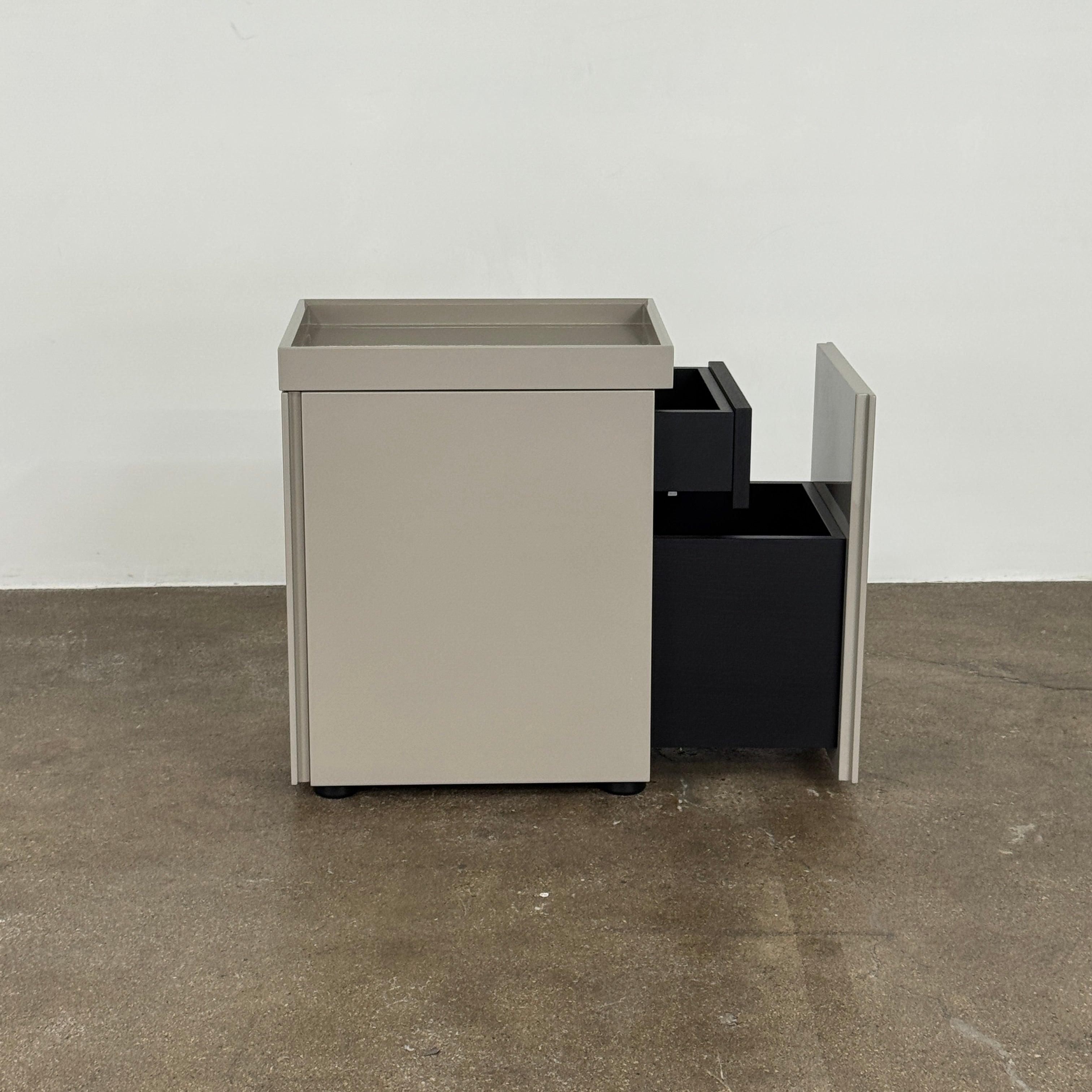 A Rev-A-Shelf instruction sheet and a "100% Thought&Made in Italy" leaflet sit on two beige trays, ideal for organizing your workspace or pairing with the Flexform Benjamin Chest of Drawers With File Insert.