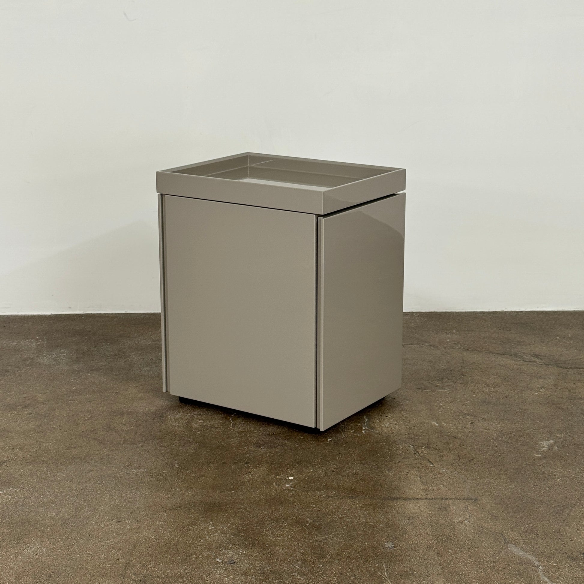 A Rev-A-Shelf instruction sheet and a "100% Thought&Made in Italy" leaflet sit on two beige trays, ideal for organizing your workspace or pairing with the Flexform Benjamin Chest of Drawers With File Insert.