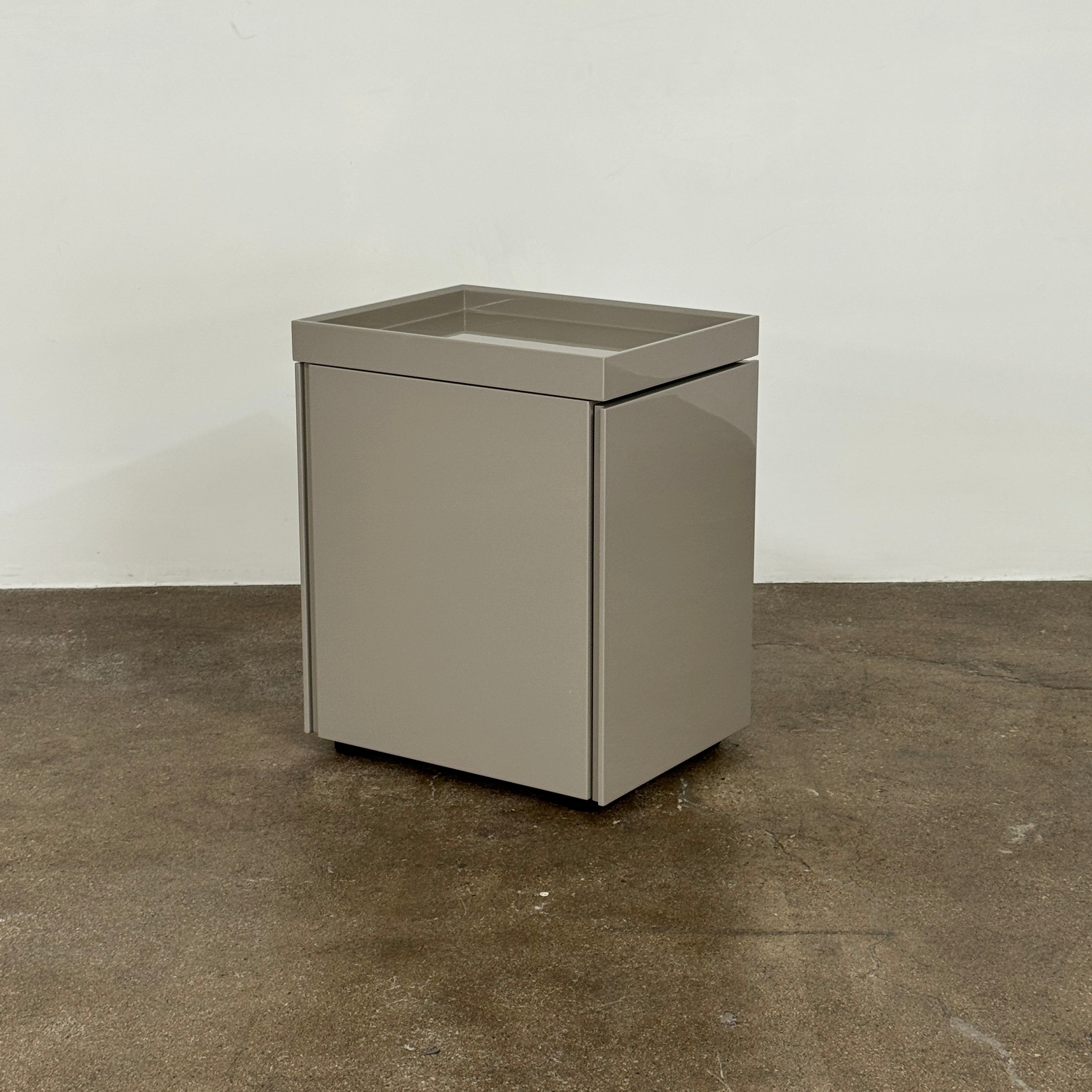 A Rev-A-Shelf instruction sheet and a "100% Thought&Made in Italy" leaflet sit on two beige trays, ideal for organizing your workspace or pairing with the Flexform Benjamin Chest of Drawers With File Insert.