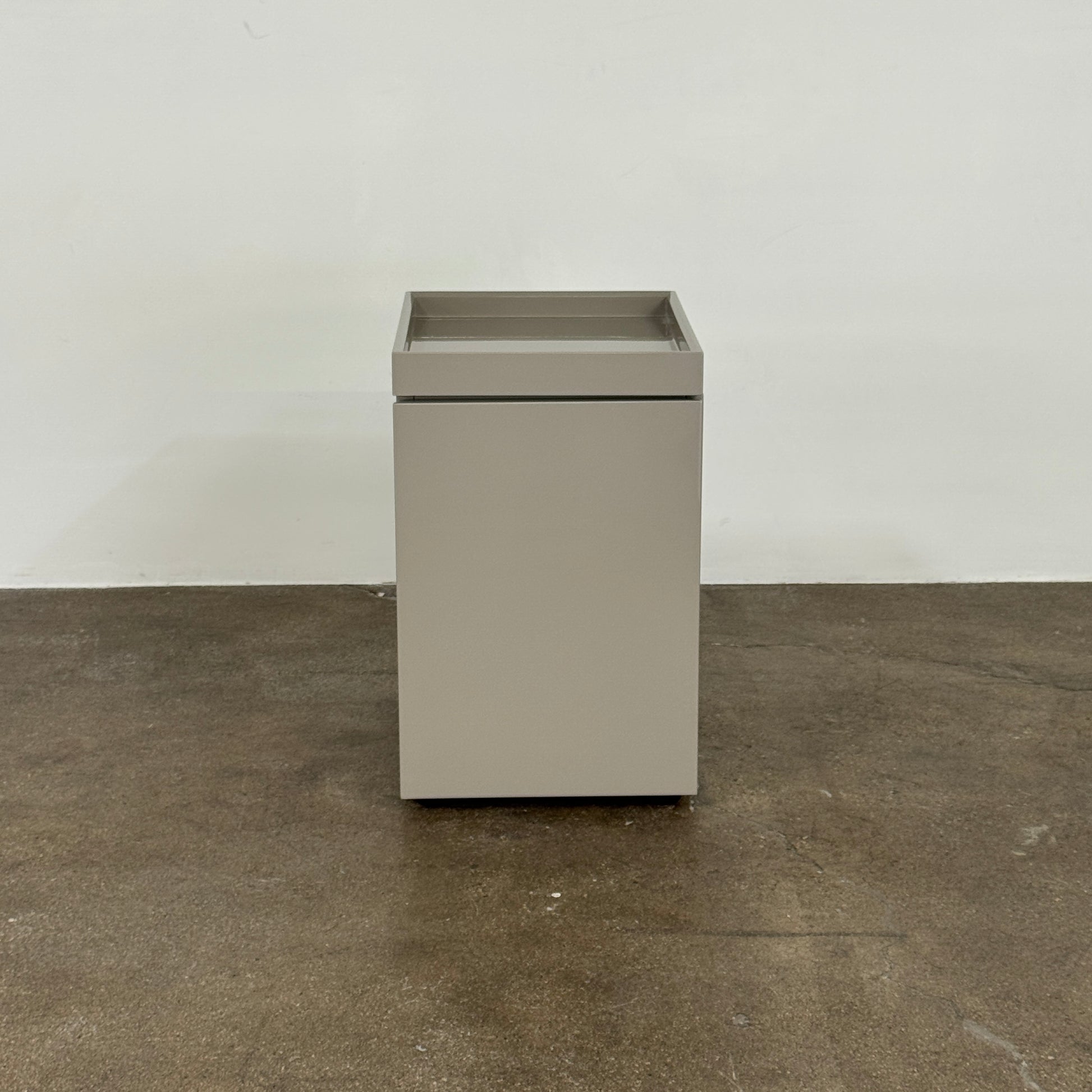 A Rev-A-Shelf instruction sheet and a "100% Thought&Made in Italy" leaflet sit on two beige trays, ideal for organizing your workspace or pairing with the Flexform Benjamin Chest of Drawers With File Insert.