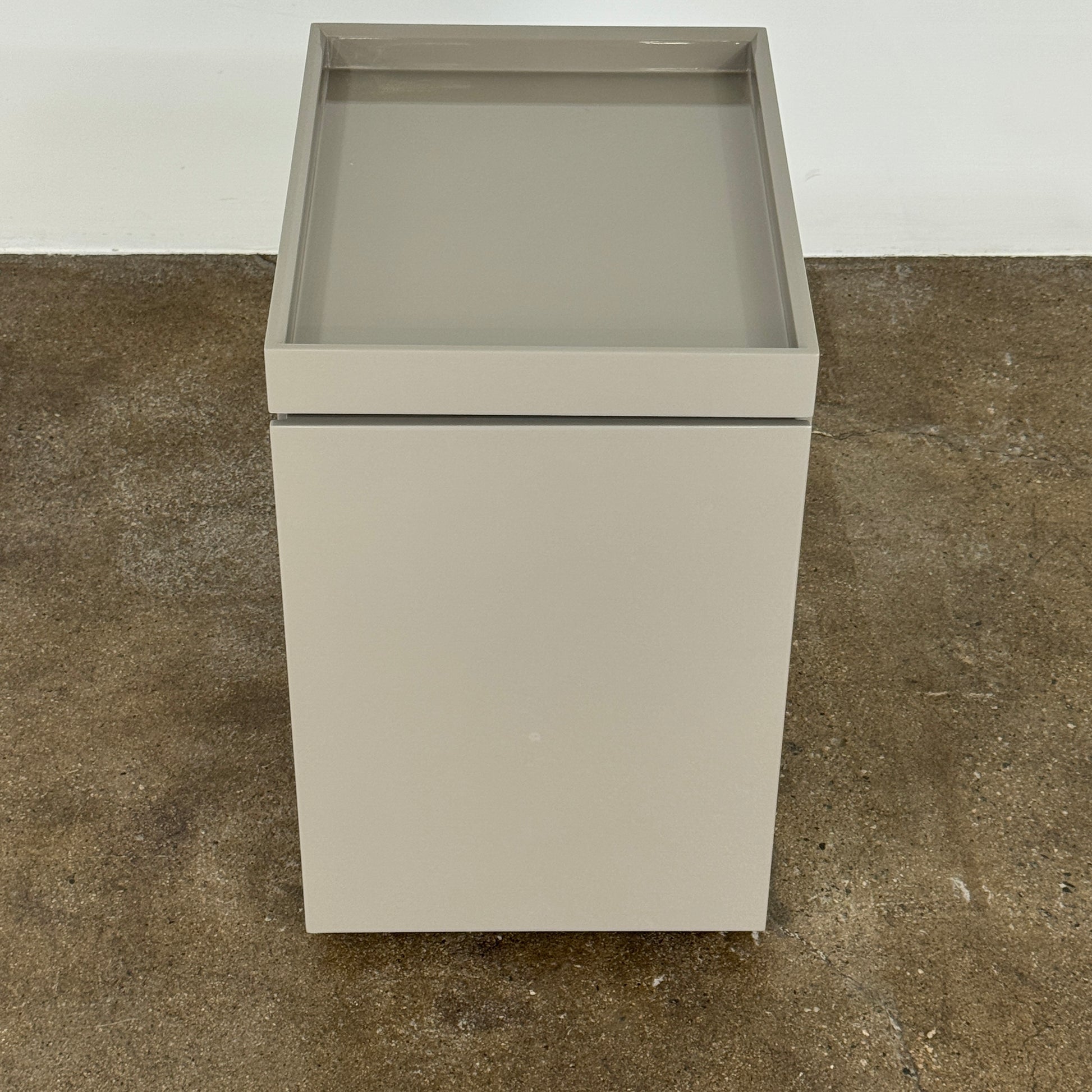 A Rev-A-Shelf instruction sheet and a "100% Thought&Made in Italy" leaflet sit on two beige trays, ideal for organizing your workspace or pairing with the Flexform Benjamin Chest of Drawers With File Insert.