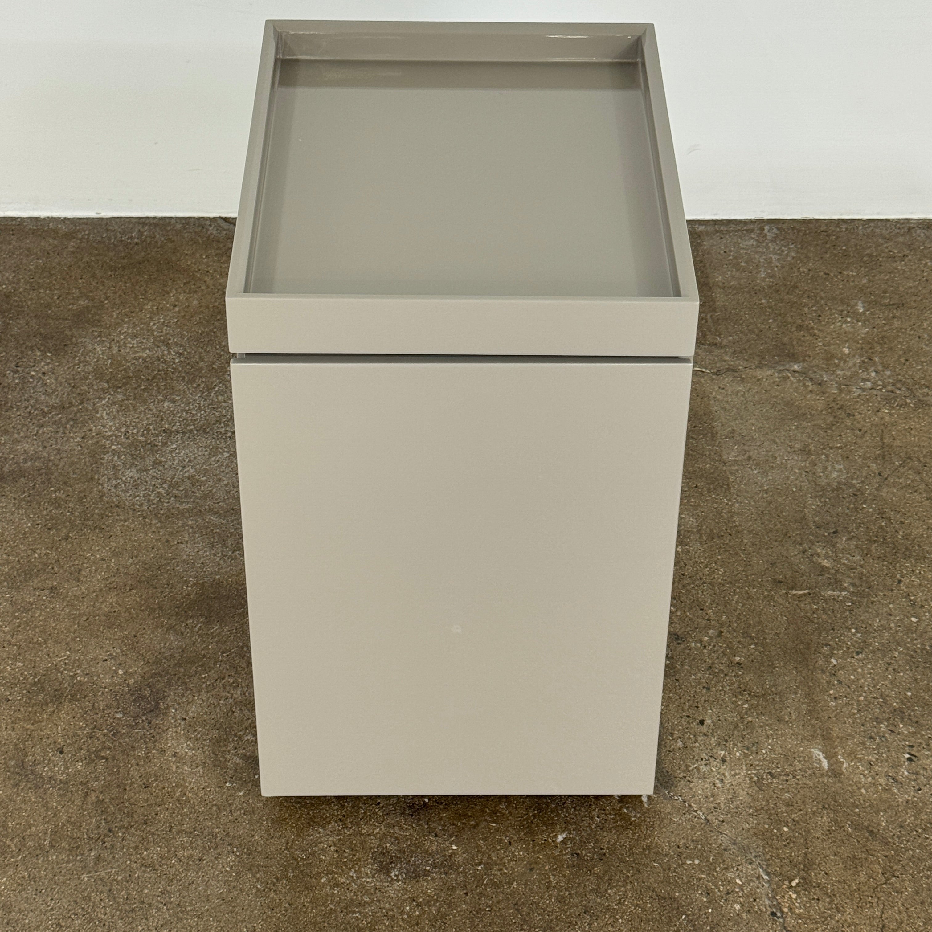 A Rev-A-Shelf instruction sheet and a "100% Thought&Made in Italy" leaflet sit on two beige trays, ideal for organizing your workspace or pairing with the Flexform Benjamin Chest of Drawers With File Insert.